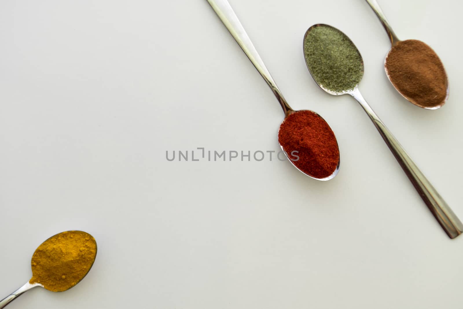 Various colorful spices arranged on spoons  by arvidnorberg