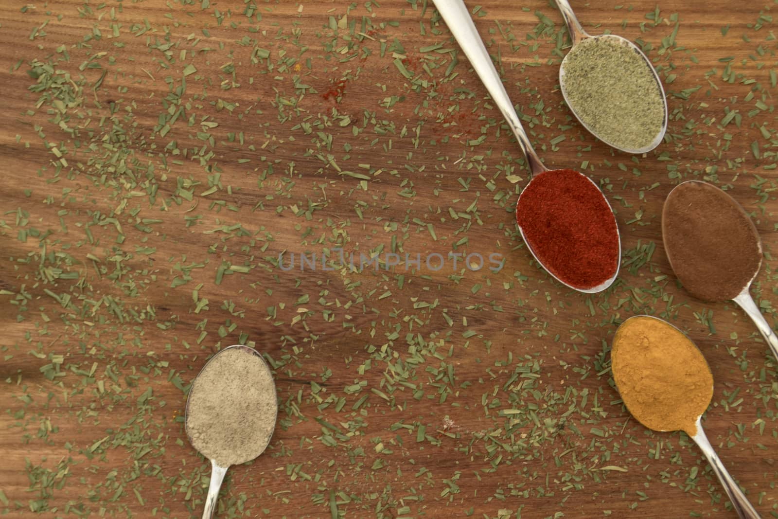 Various colorful spices arranged on spoons  by arvidnorberg