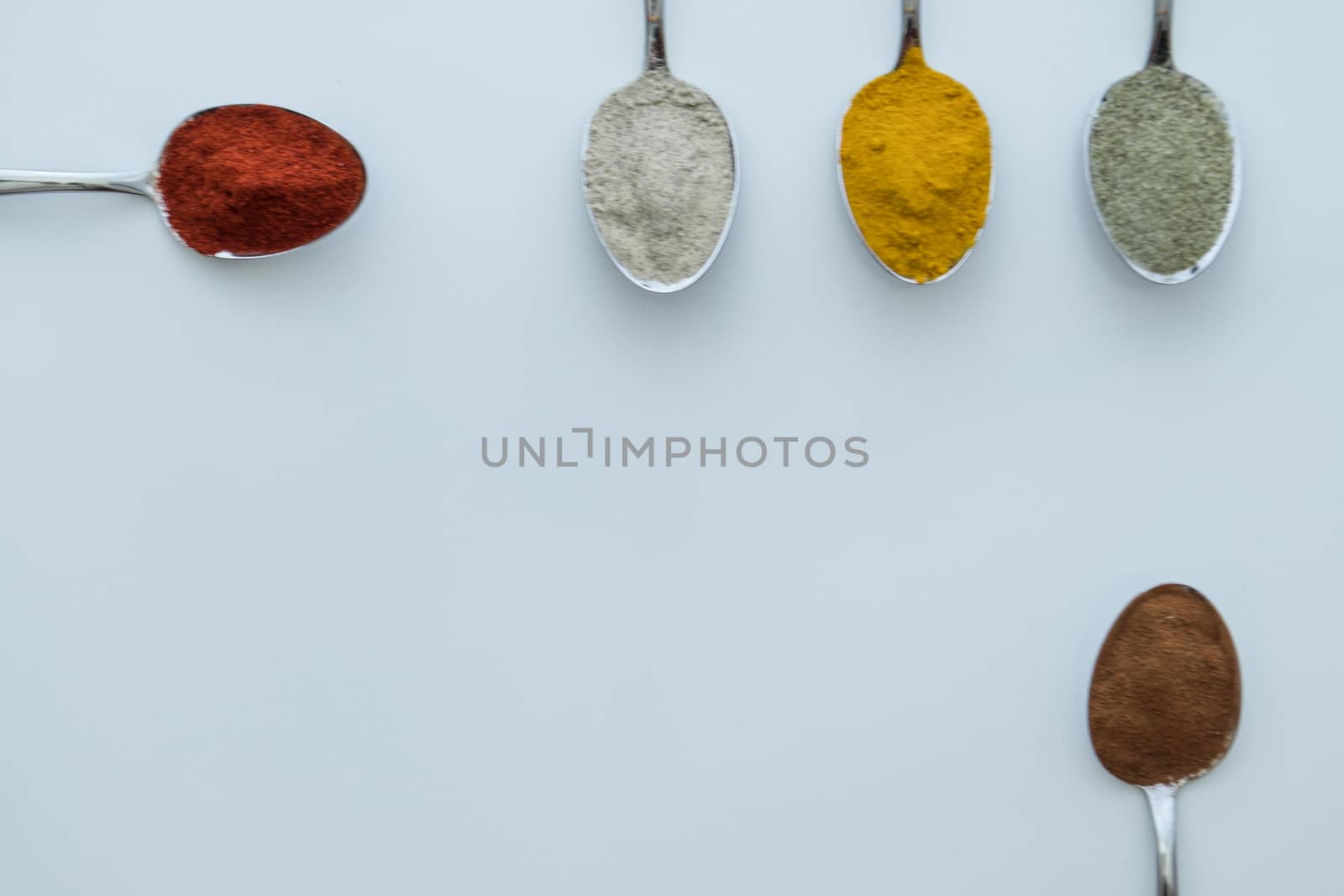 Various colorful spices arranged on spoons  by arvidnorberg