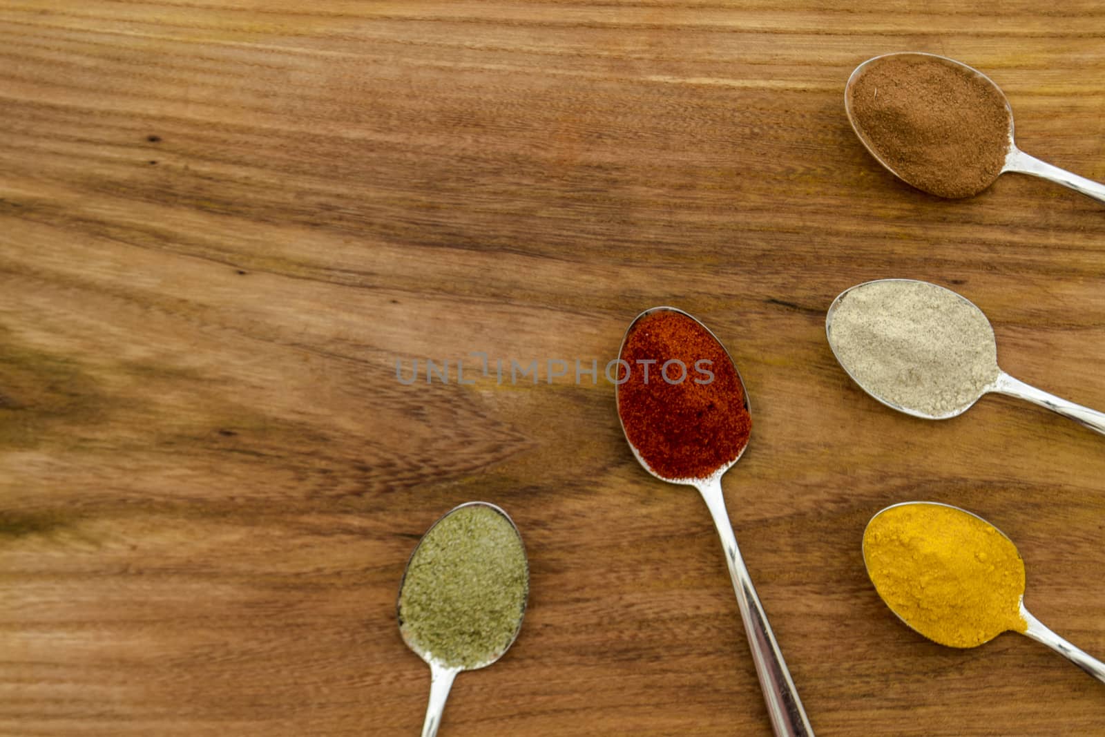 Various colorful spices arranged on spoons  by arvidnorberg