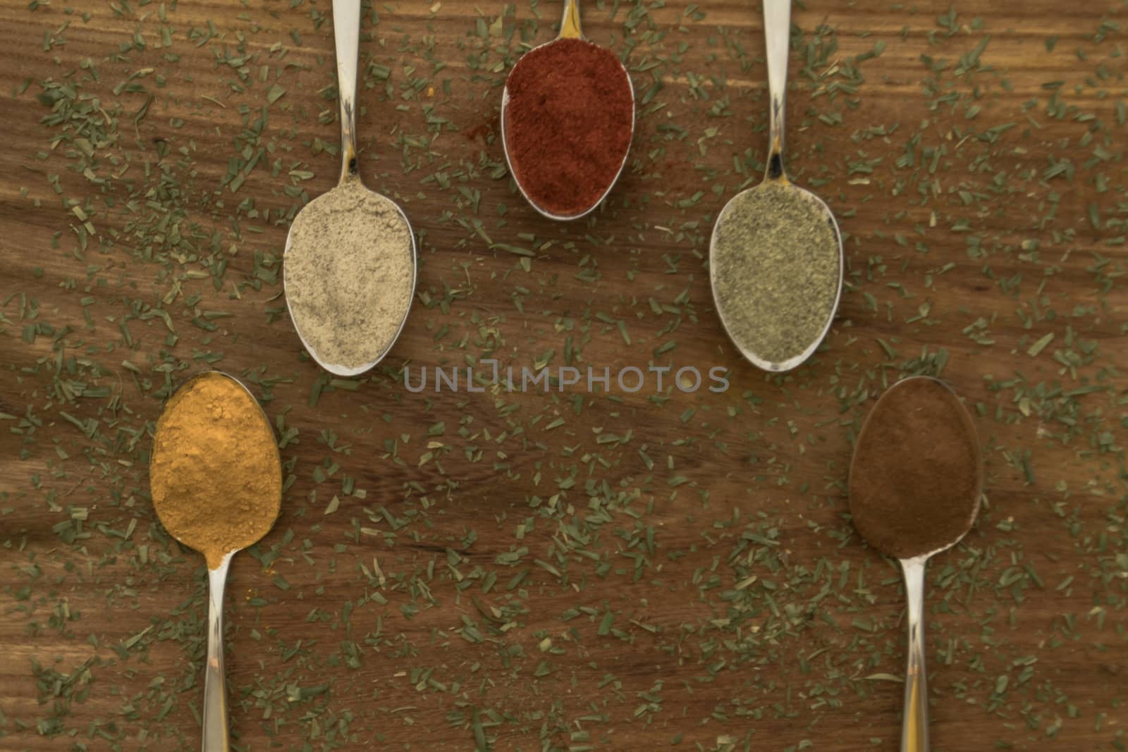 Various colorful spices arranged on spoons  by arvidnorberg