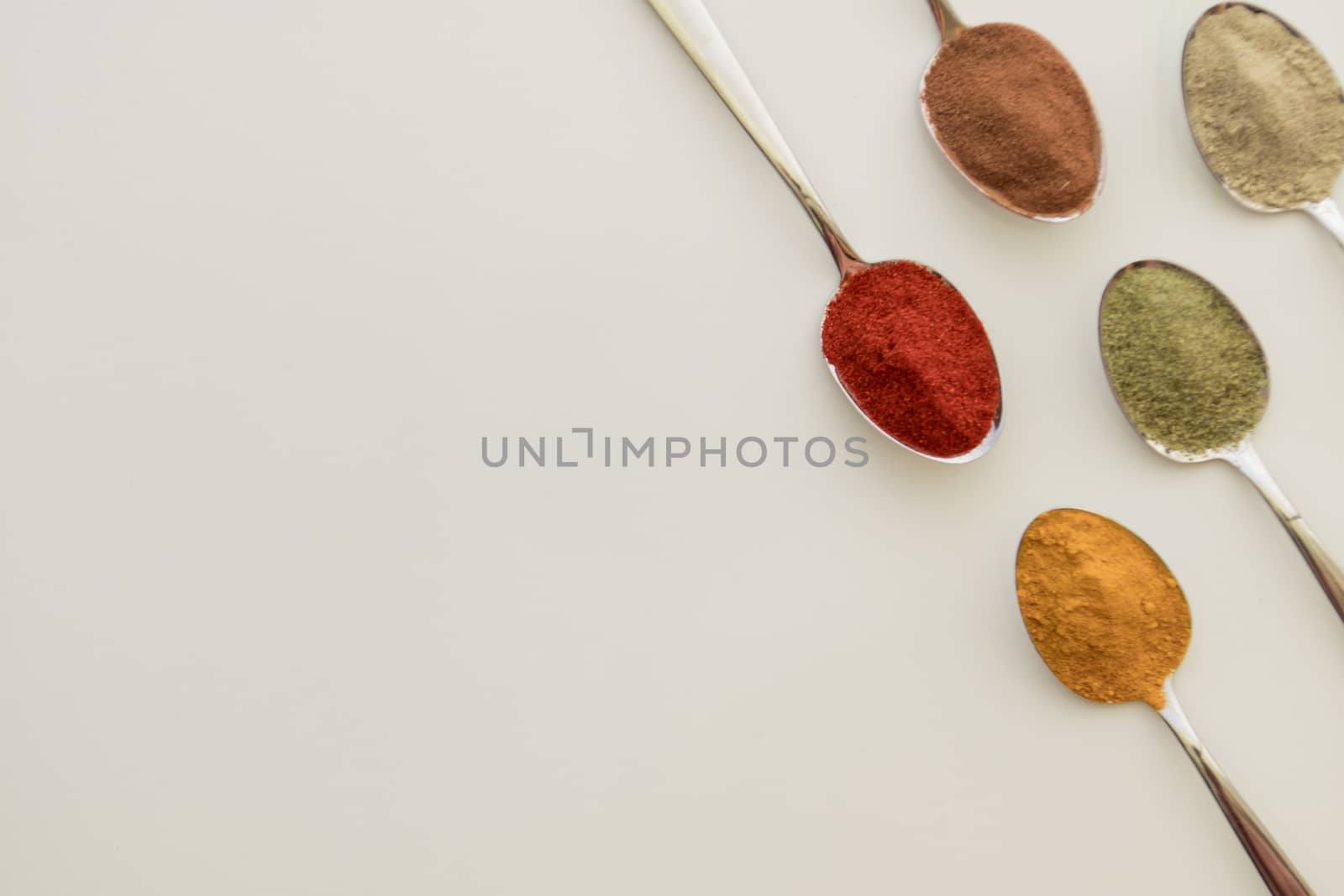 Various colorful spices arranged on spoons  by arvidnorberg