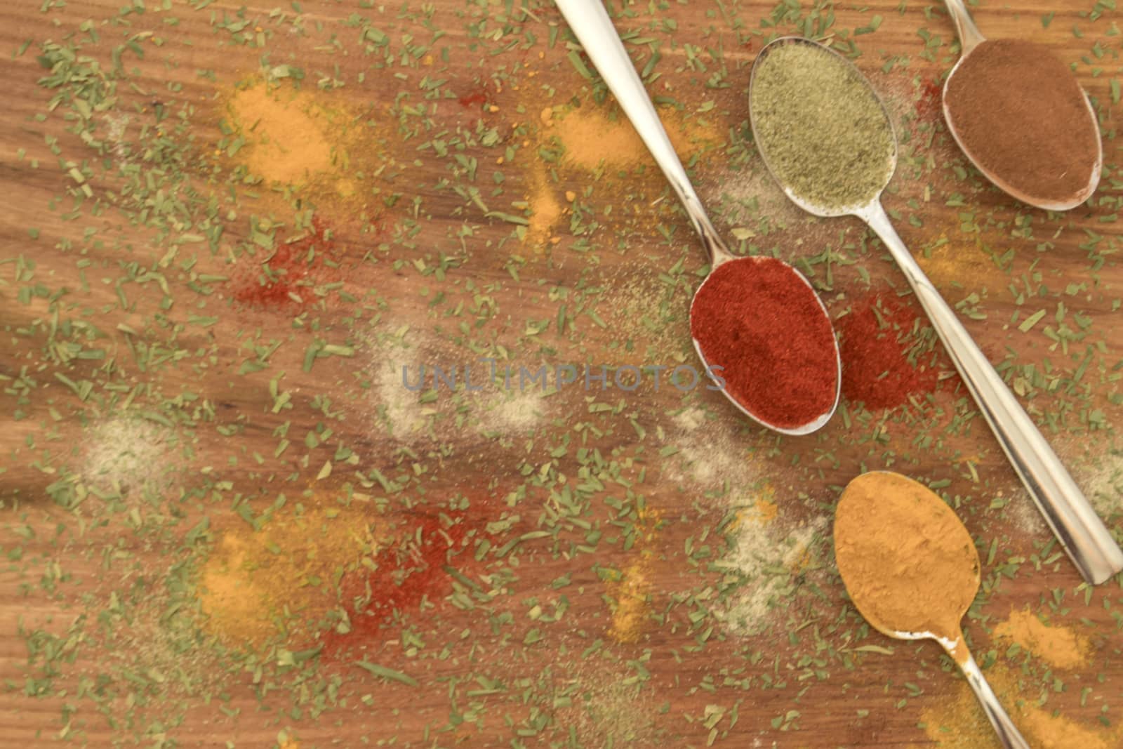 Various colorful spices arranged on spoons  by arvidnorberg