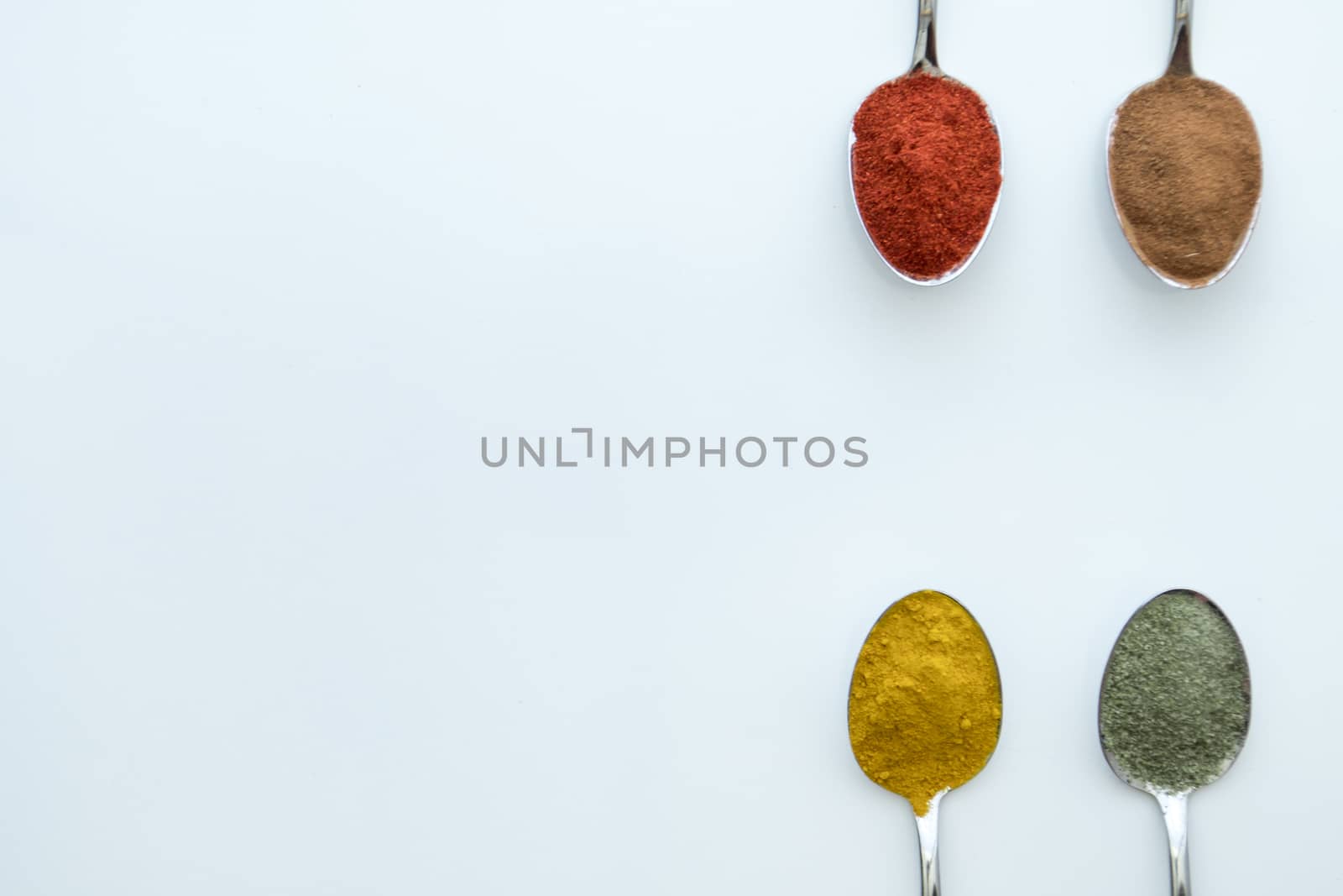 Various colorful spices arranged on spoons  by arvidnorberg