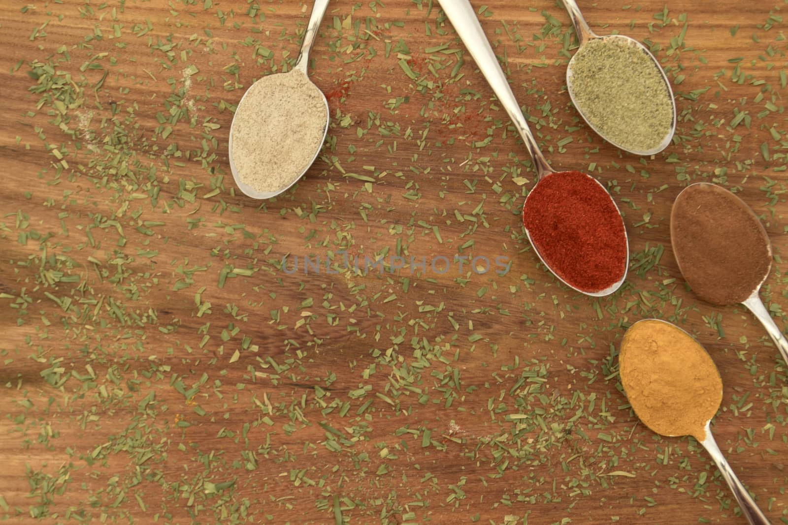 Various colorful spices arranged on spoons  by arvidnorberg