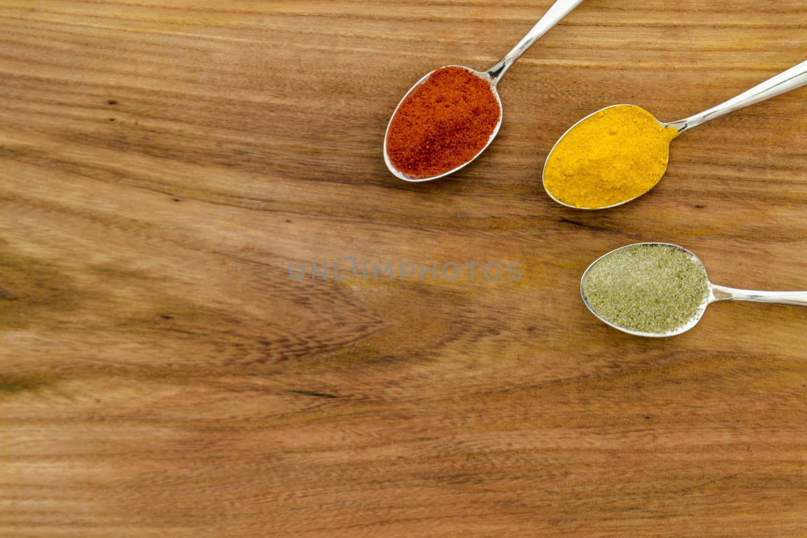 Various colorful spices arranged on spoons  by arvidnorberg