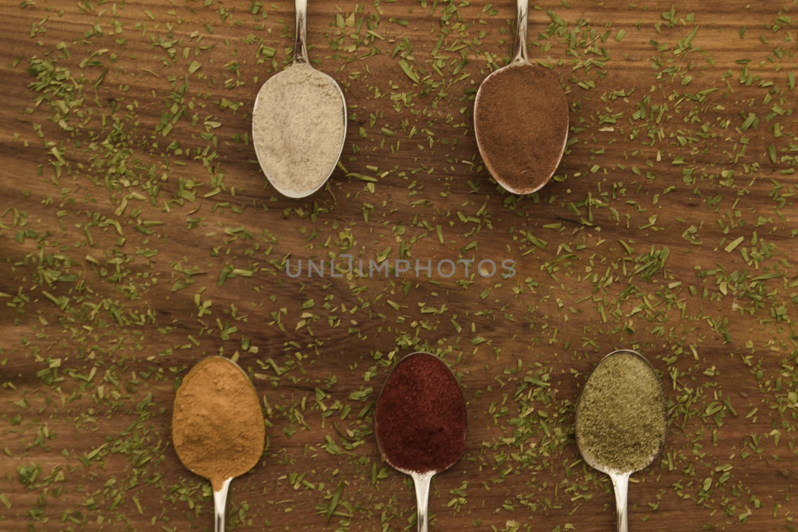 Various colorful spices arranged on spoons  by arvidnorberg