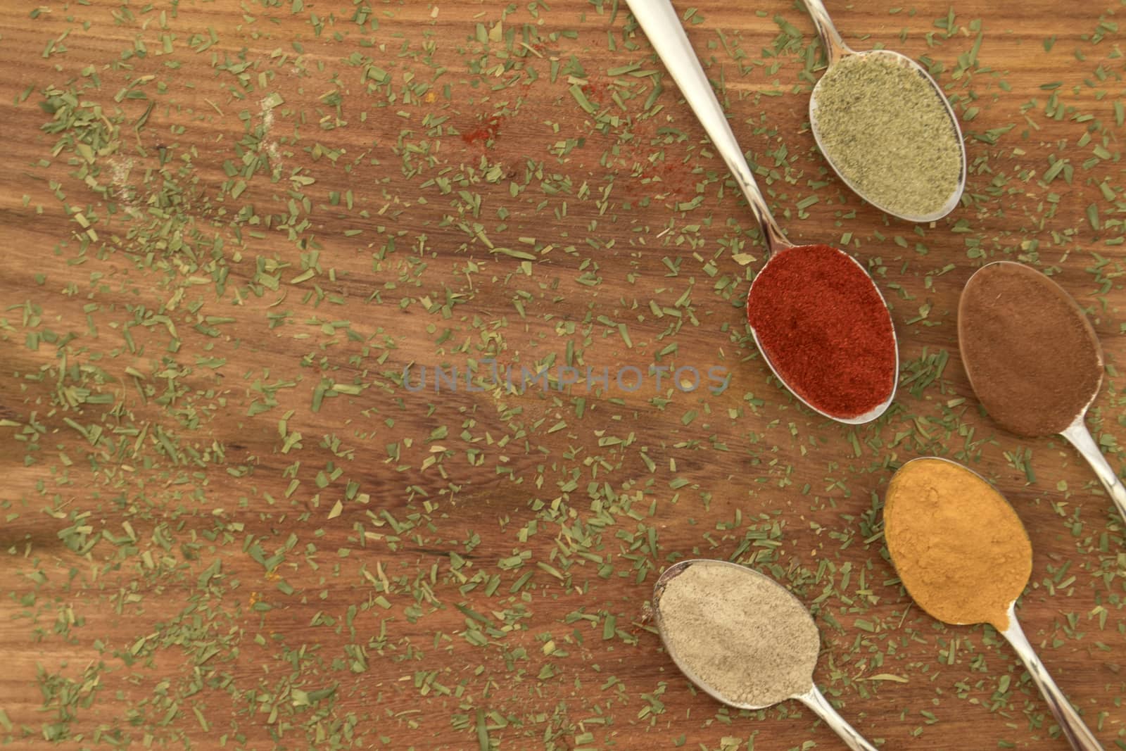 Various colorful spices arranged on spoons  by arvidnorberg