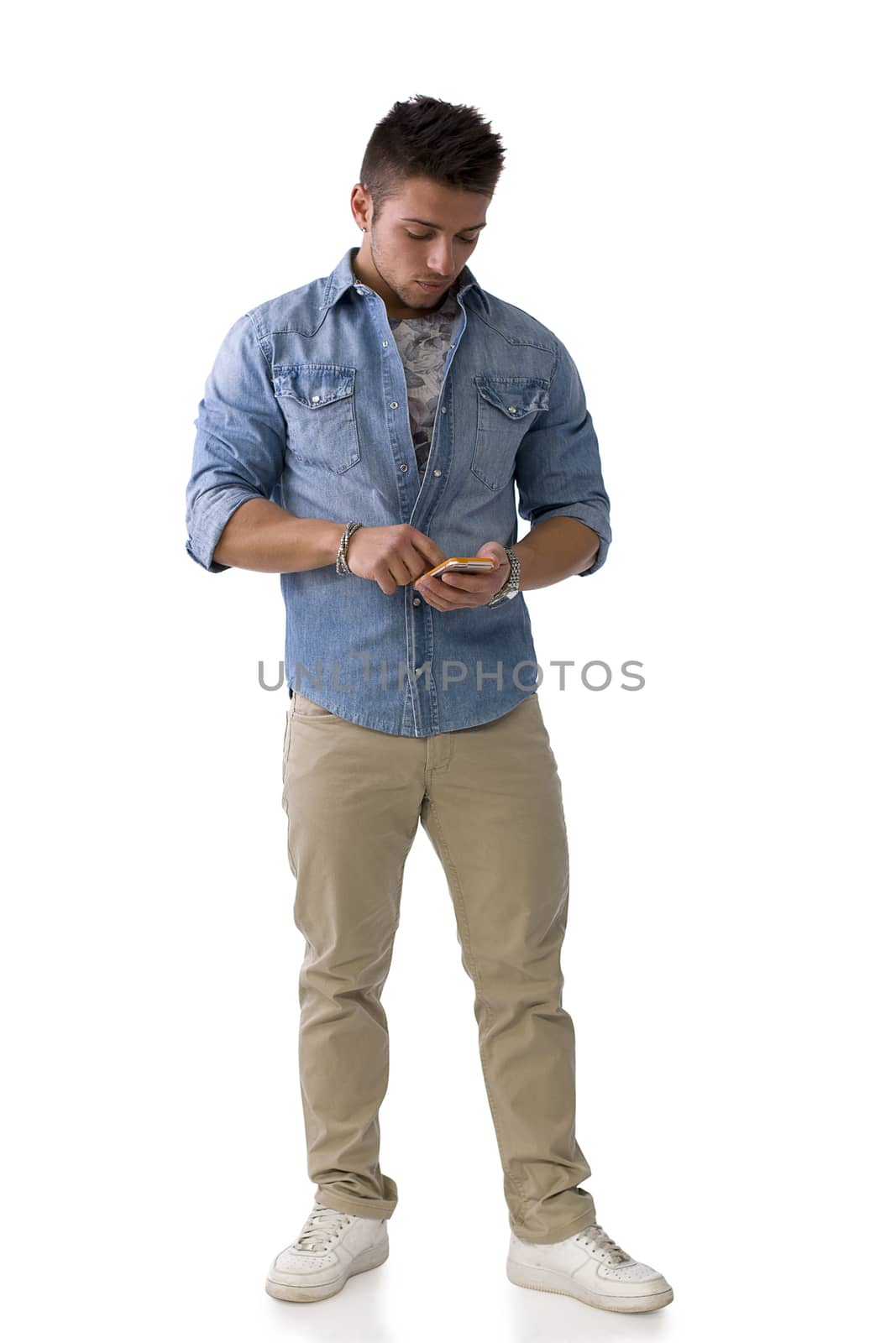 Handsome young man checking watch on his wrist, isolated on white. Full length shot