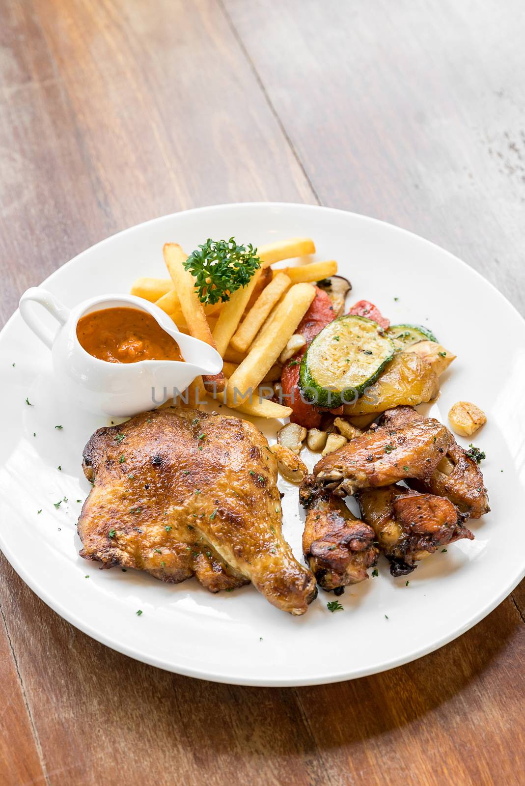 grilled chicken peri peri, BBQ Portuguese groumet griled cuisine, with fries and grilled vegetable.