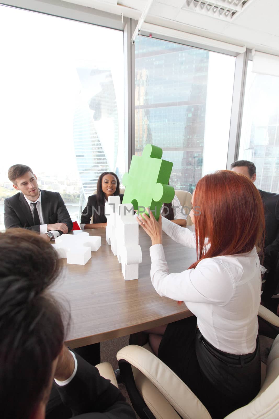 Business people assembling puzzle by ALotOfPeople