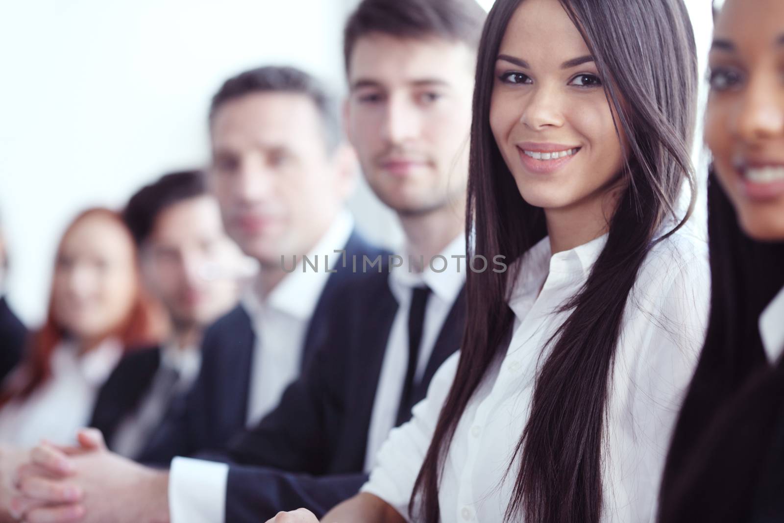 Business people sitting in a row and working, focus on pretty woman