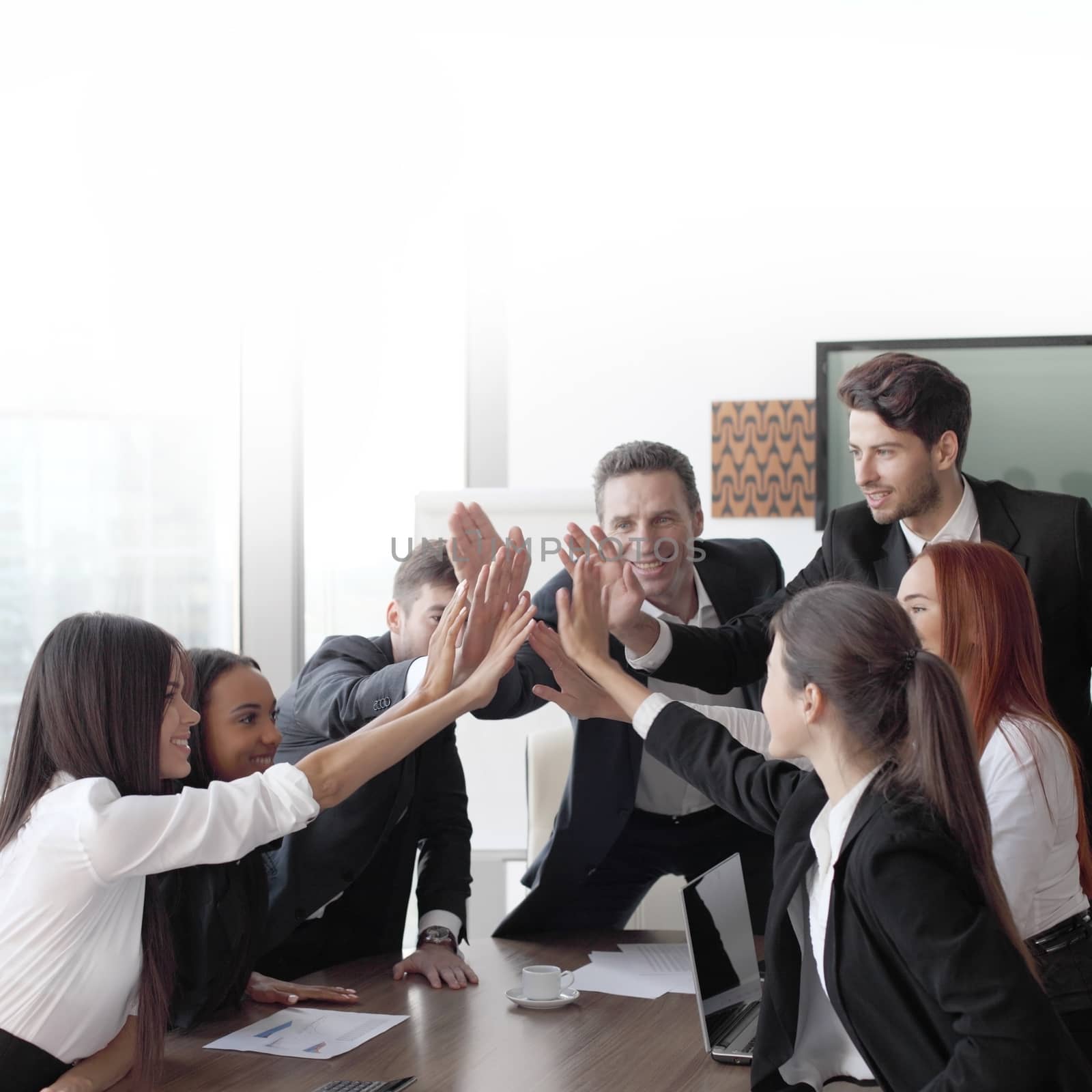 Happy business team making high five with their hands in the office