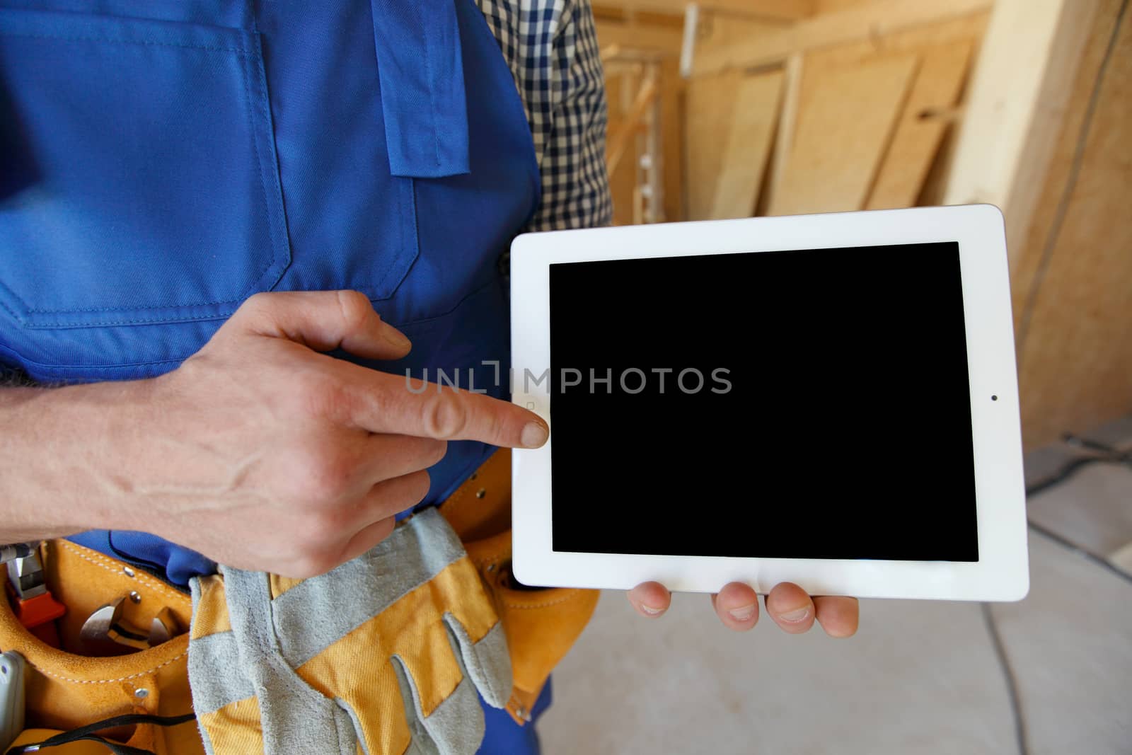Worker pointing at tablet by ALotOfPeople