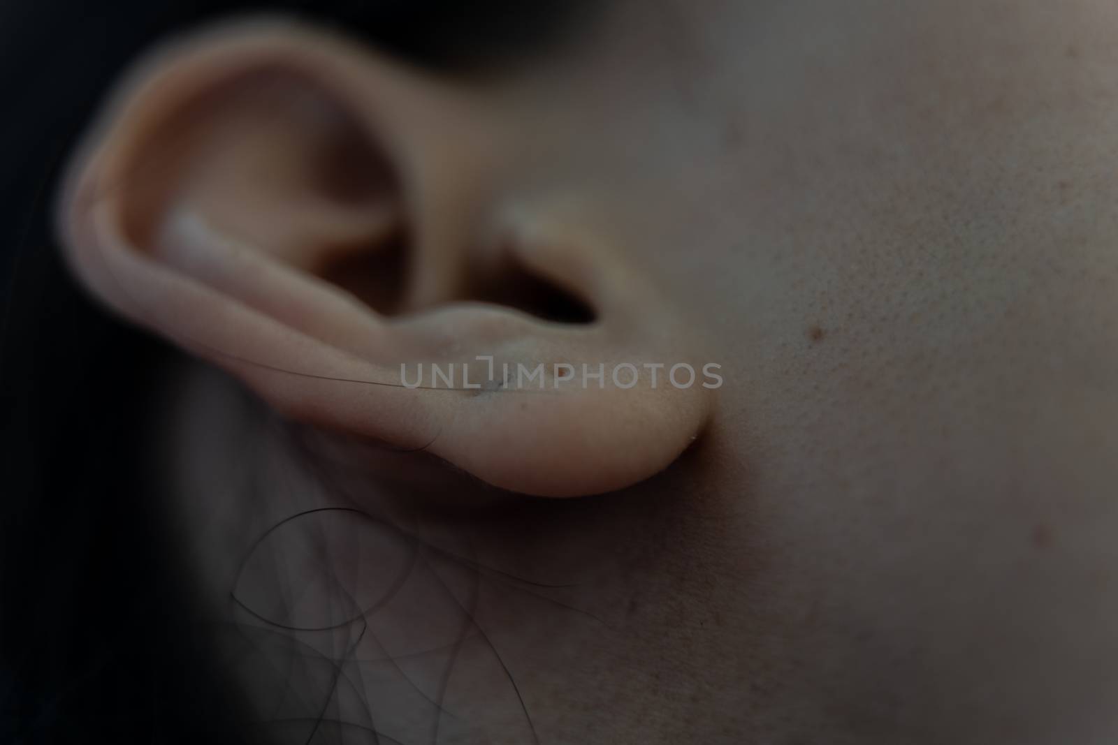 Close up of human head with female ear. Listening or deafness concept