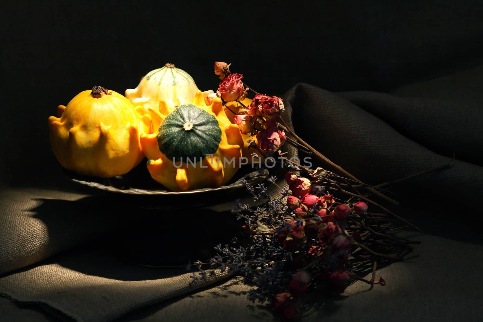 Vintage still life with few small pumpkins in old metal bowl