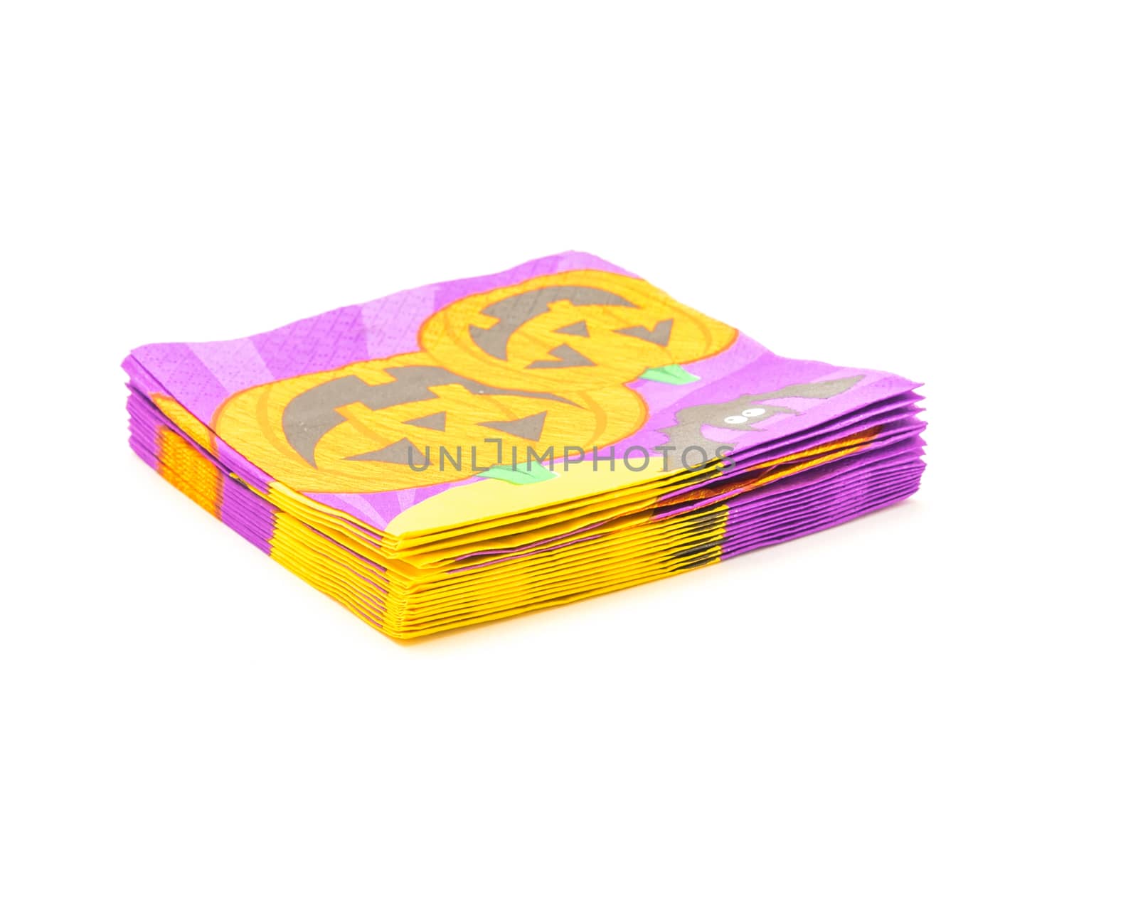 Stack of friendly Halloween napkins isolated on white background. Festive party tissue piles display pumpkins, bats, jack-o-lantern