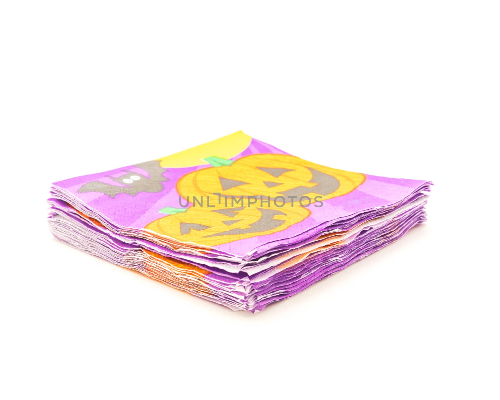 Stack of friendly Halloween napkins isolated on white background. Festive party tissue piles display pumpkins, bats, jack-o-lantern