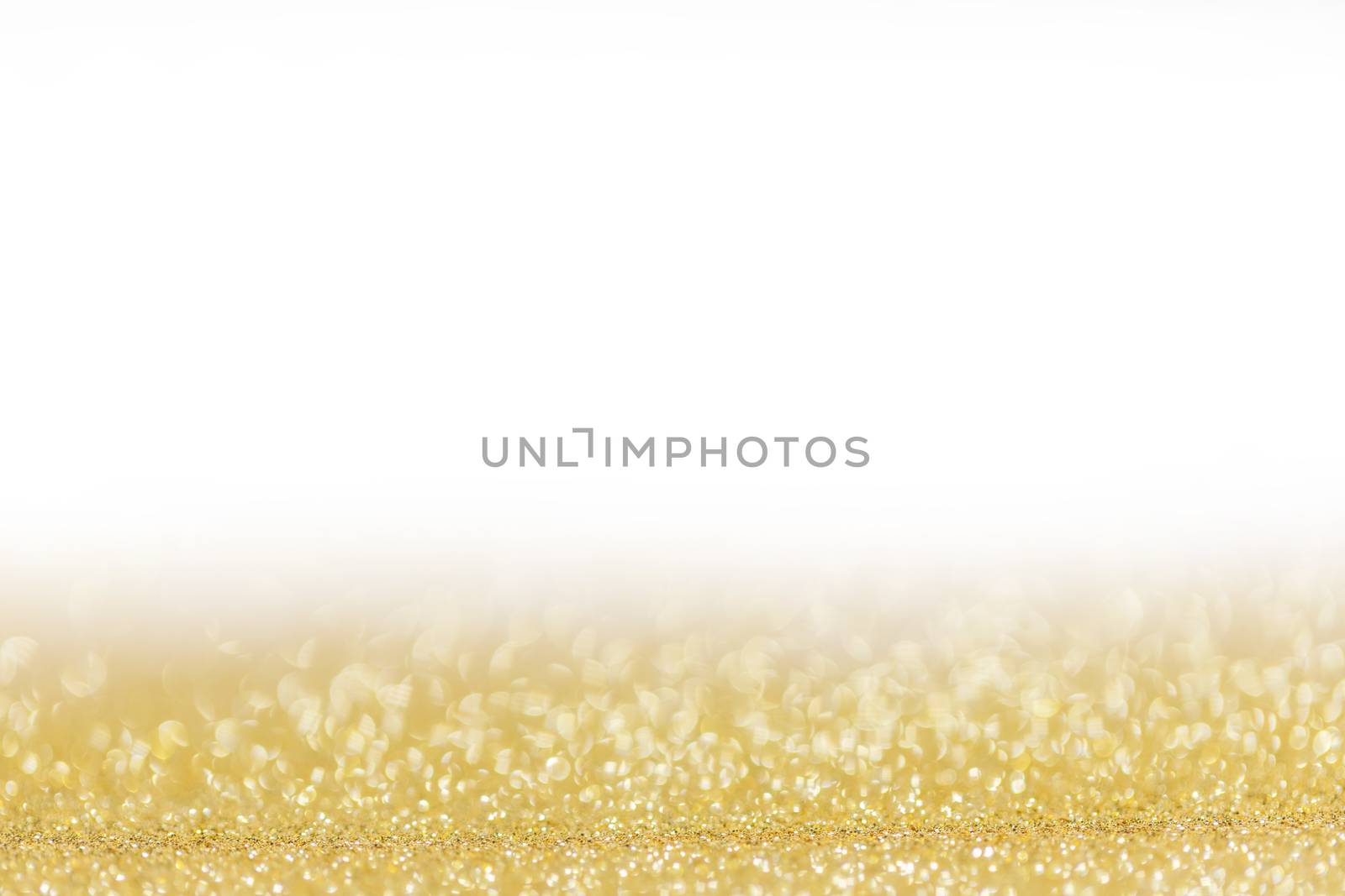 Golden festive glitter background with defocused lights , white copy space