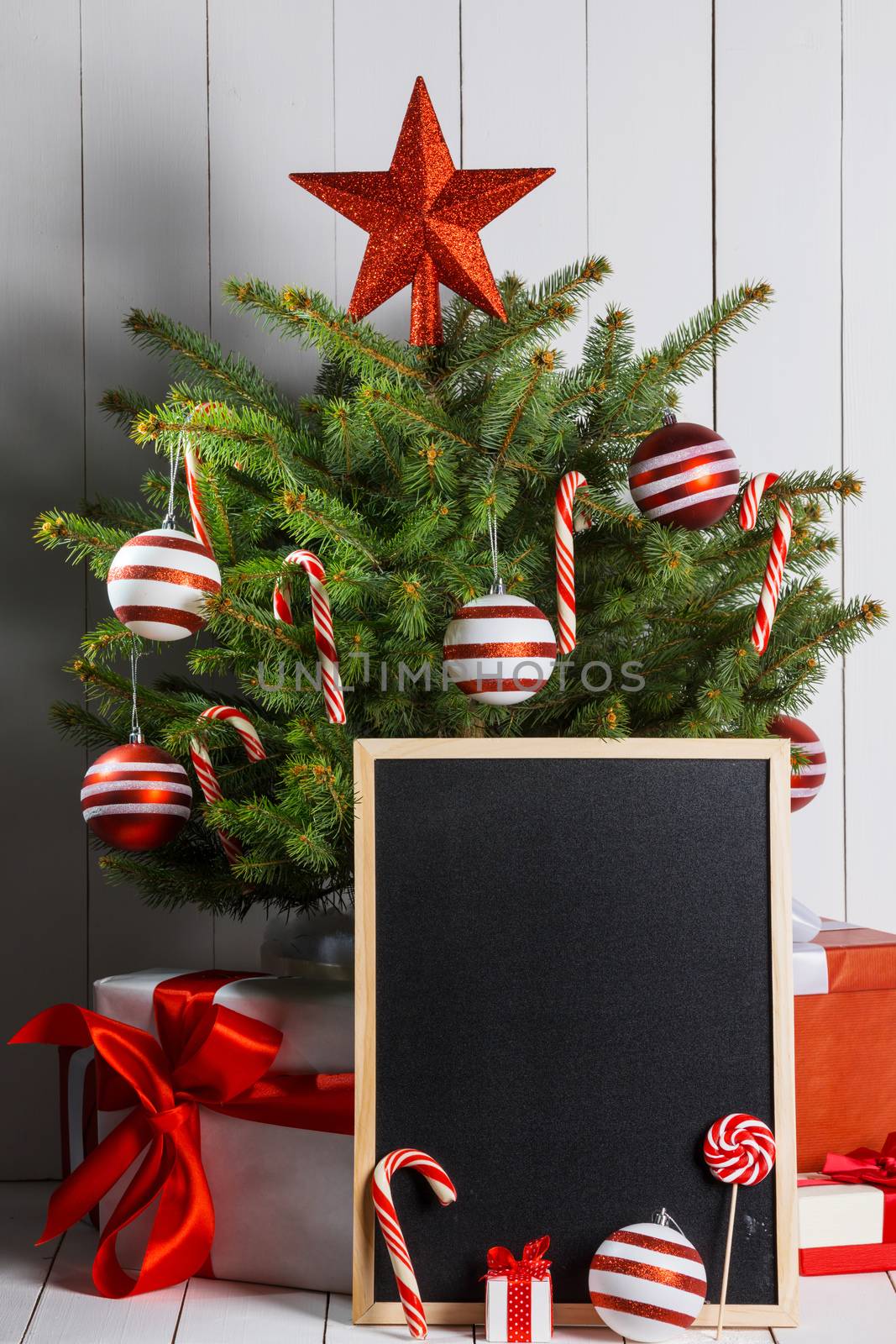 Rustic chalkboard and christmas tree decorated with candy canes and baubles