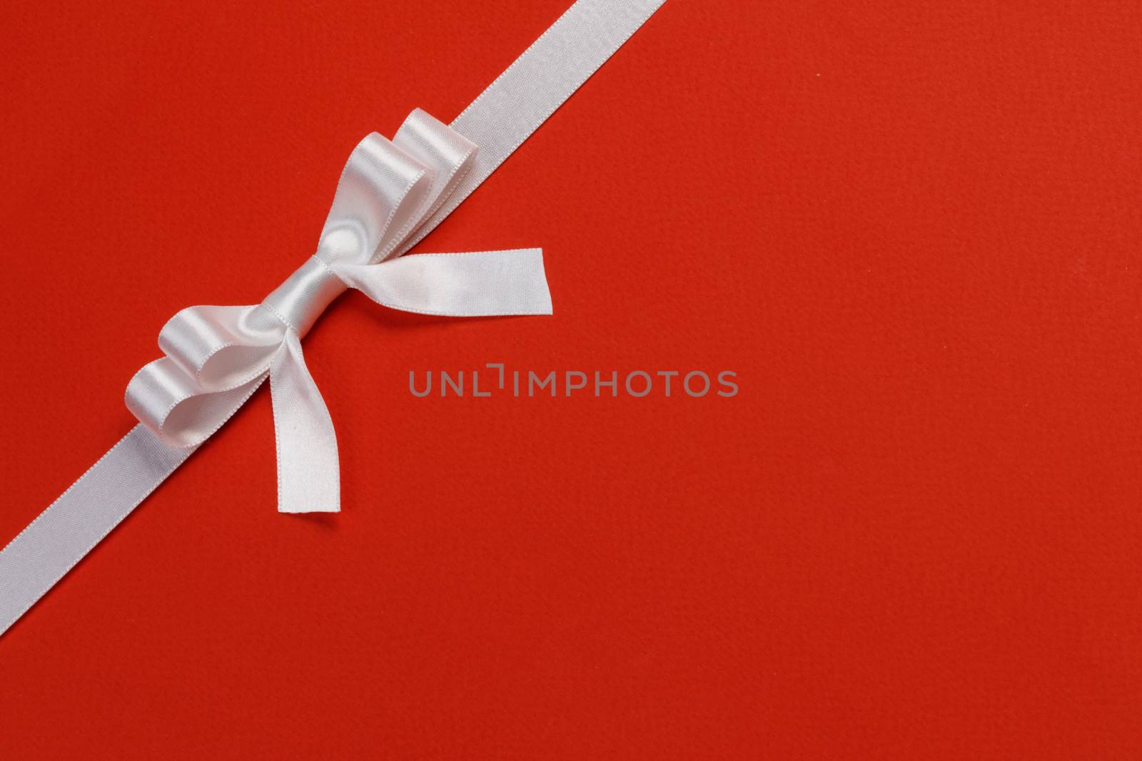 White gift bow on red background holiday gift concept