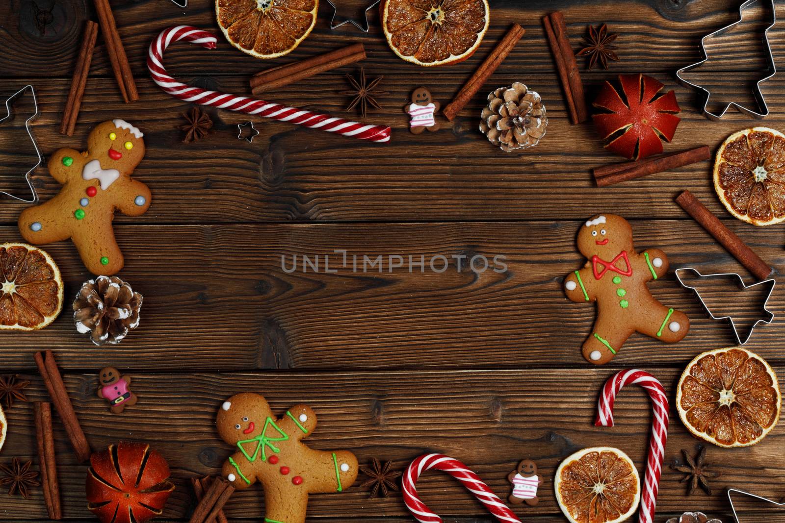 Christmas food frame. Gingerbread cookies, spices and decorations on wooden background with copy space