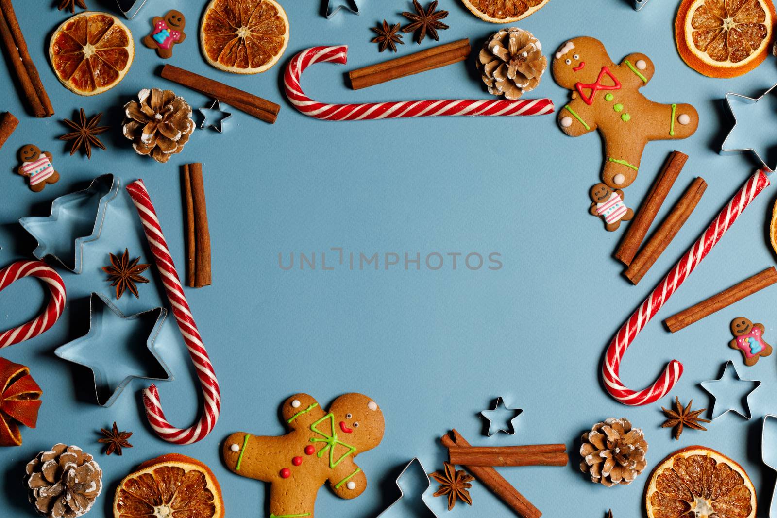 Christmas food frame. Gingerbread cookies, spices and decorations on blue background with copy space