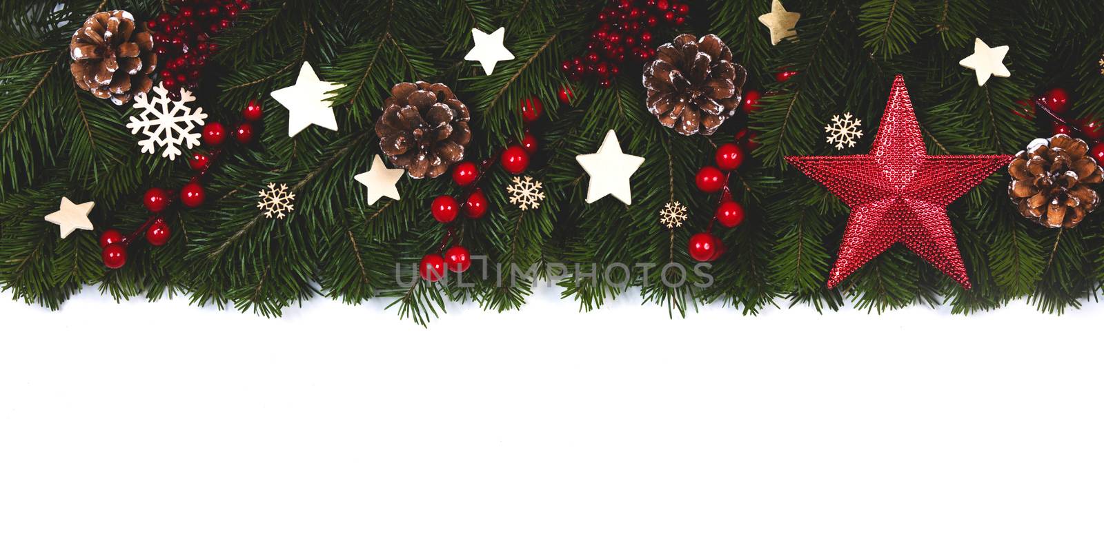 Christmas Border frame of tree branches on white background with copy space isolated, red and white decor, berries, stars, cones