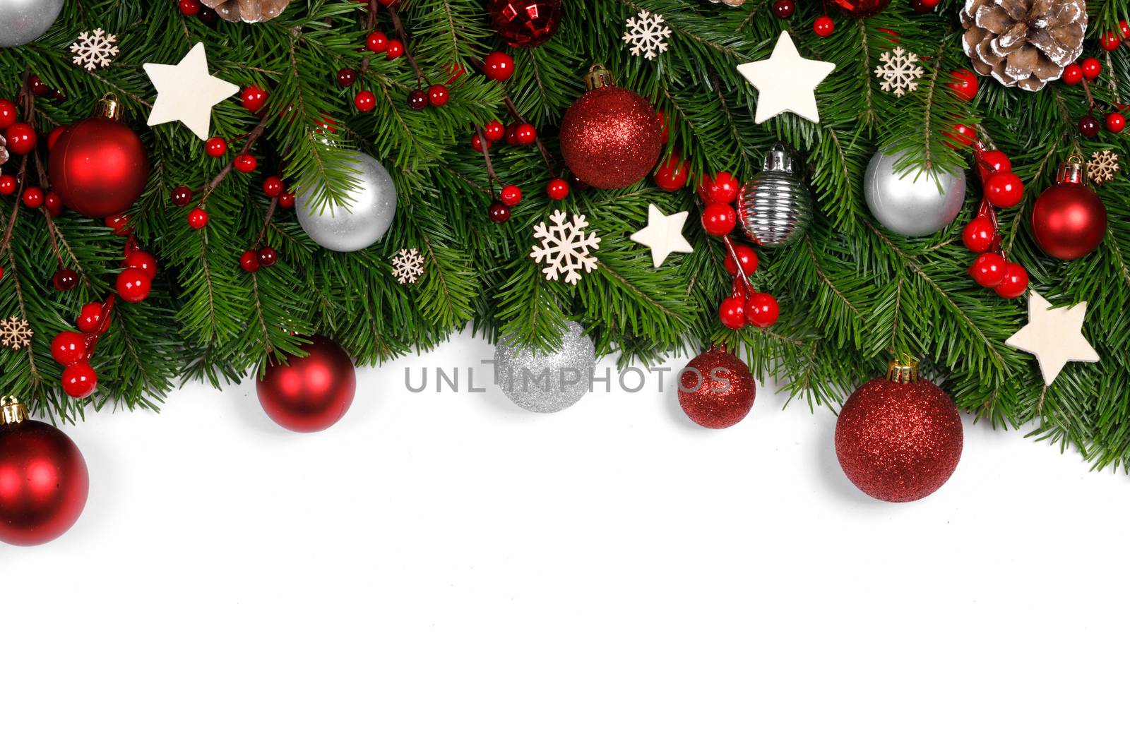 Christmas Border frame of tree branches on white background with copy space isolated, red and white decor, berries, stars, cones