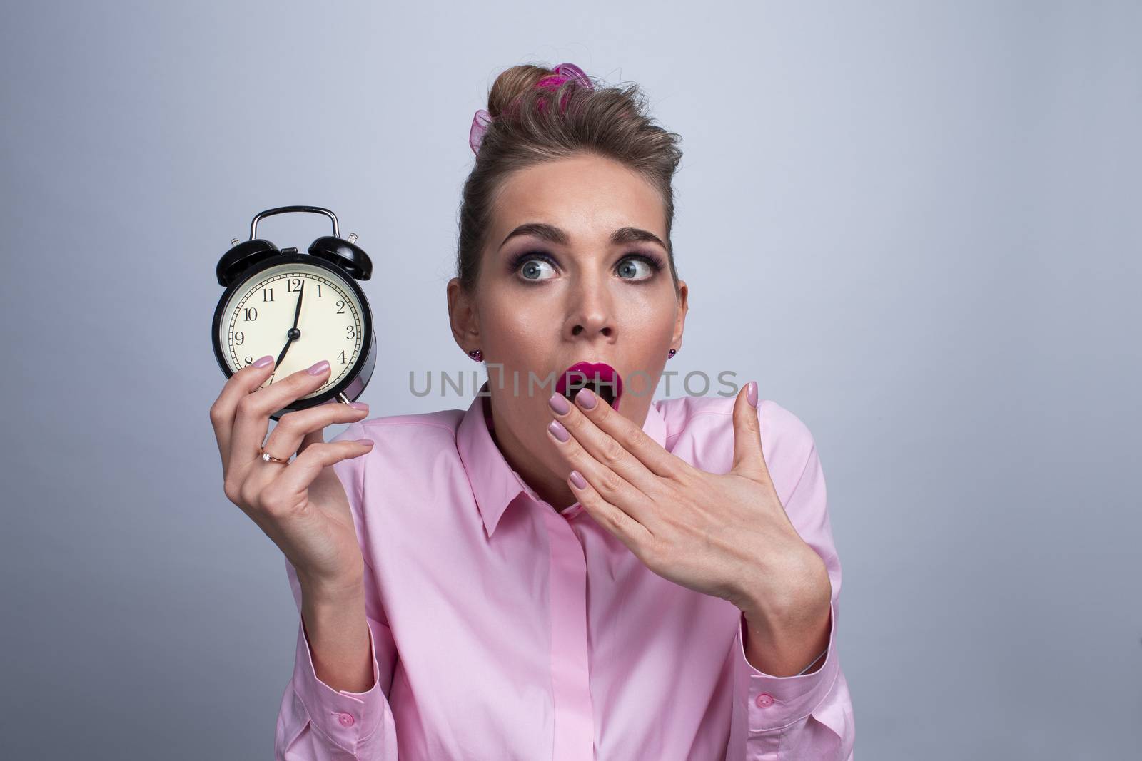 Surprised girl with alarm clock . Time management concept