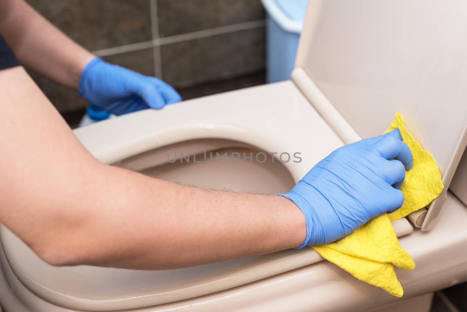 Man cleaning toilet bowl by HERRAEZ