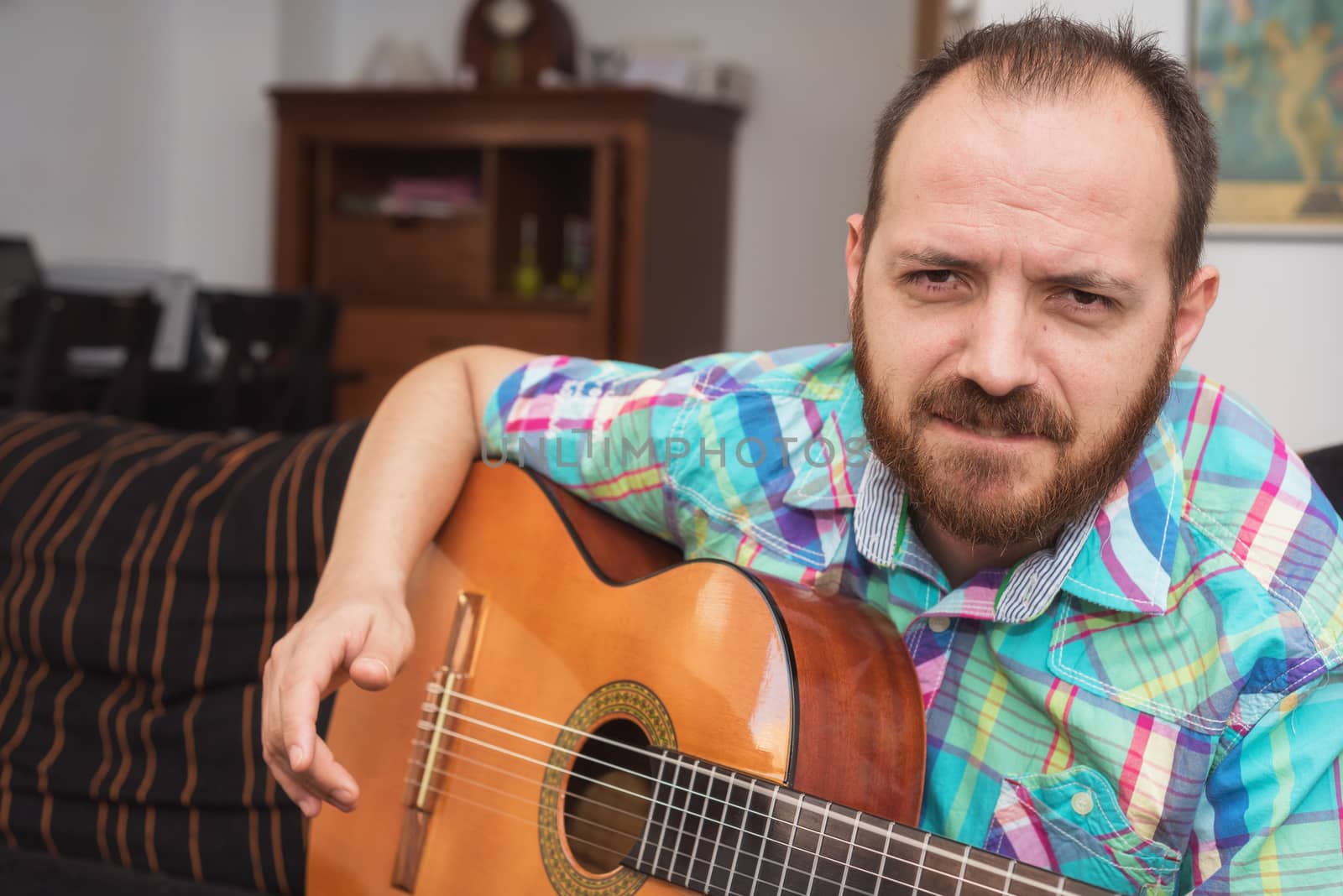 Young man musician playing acoustic guitar