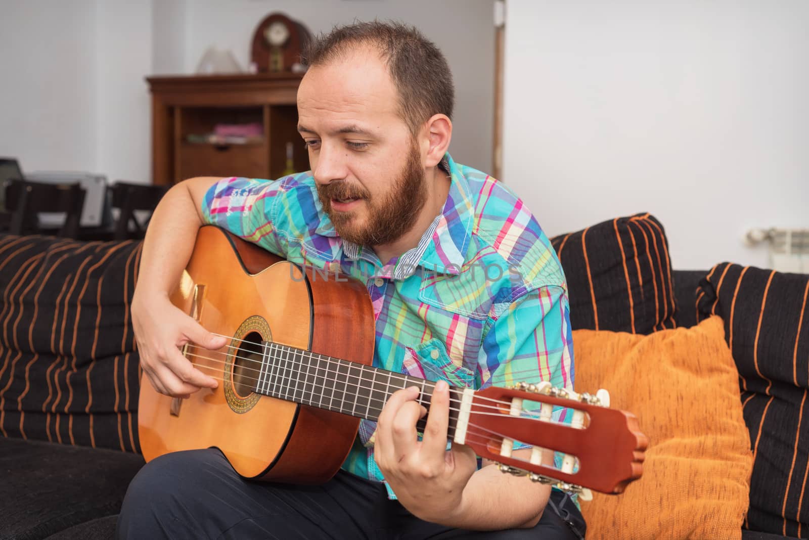 Young man musician playing acoustic guitar