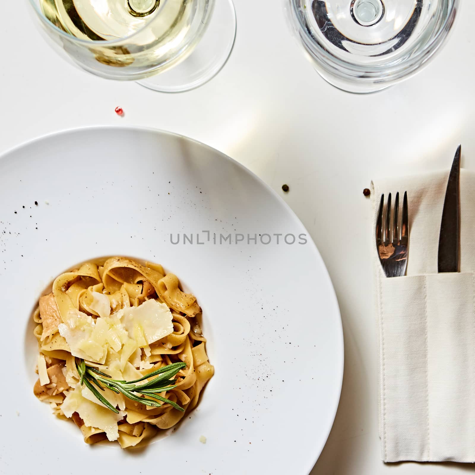 Close-up italian pasta plate with grated parmesan cheese and basil leaf by sarymsakov