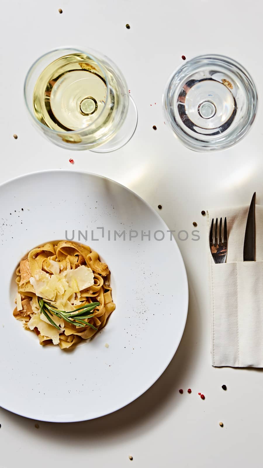 Close-up italian pasta plate with grated parmesan cheese and basil leaf by sarymsakov