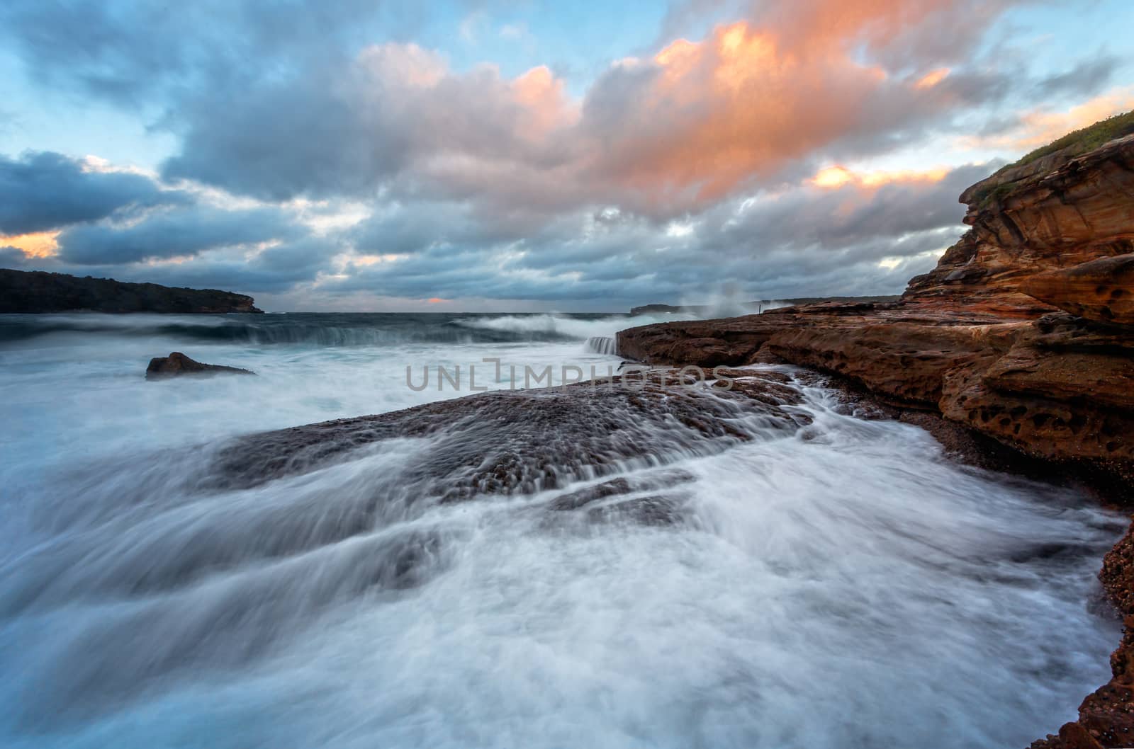 Waves crash onto the rocky shore of Bare Island by lovleah
