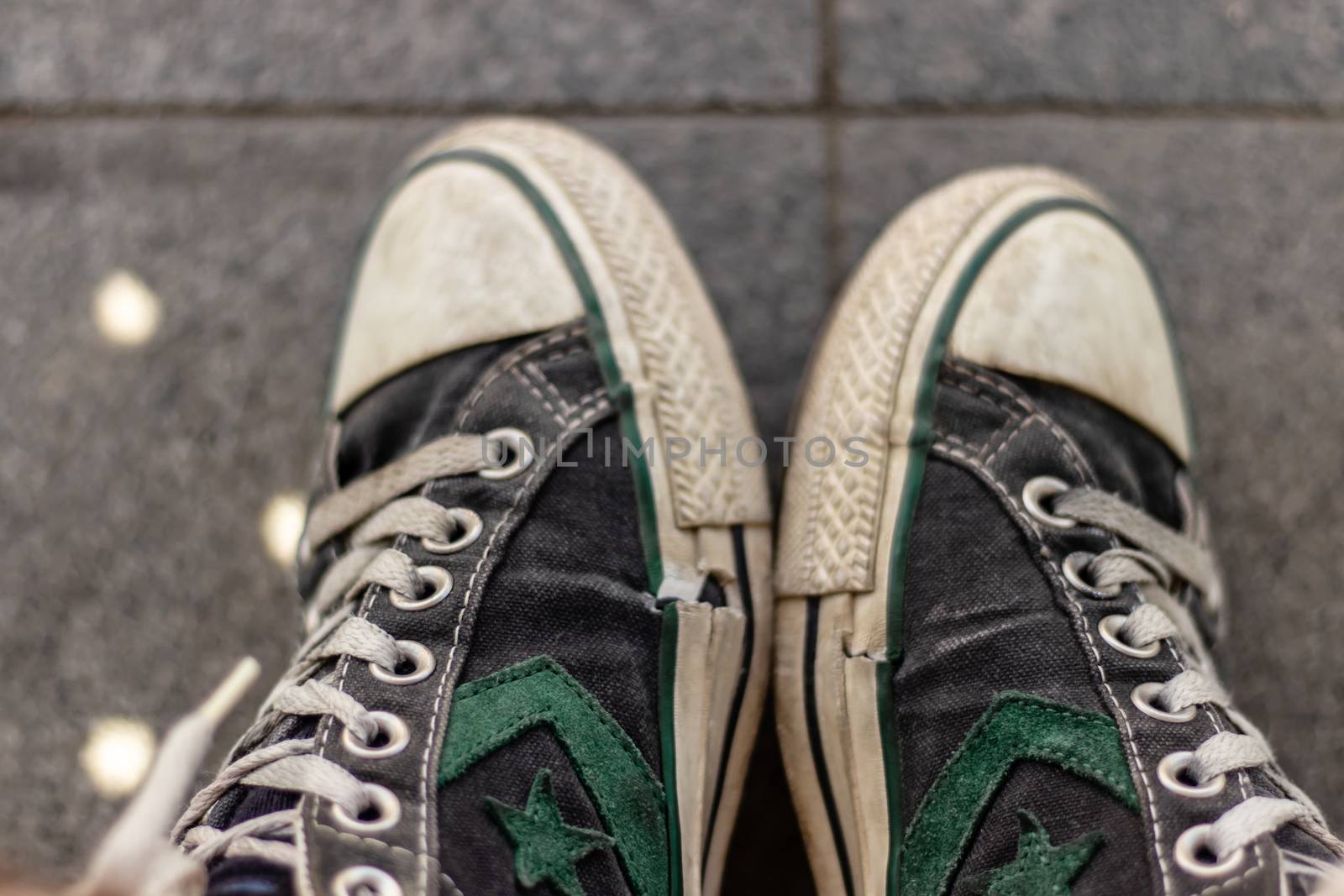 old converse all-star shoes with green star and wales on it. a closeup shoot with both foot.