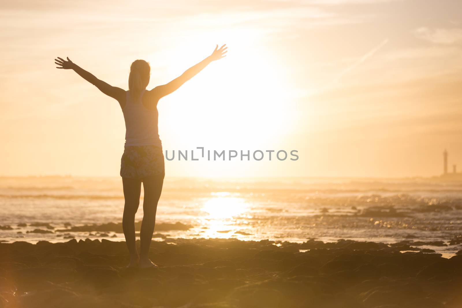 Free woman enjoying freedom on beach at sunset. by kasto