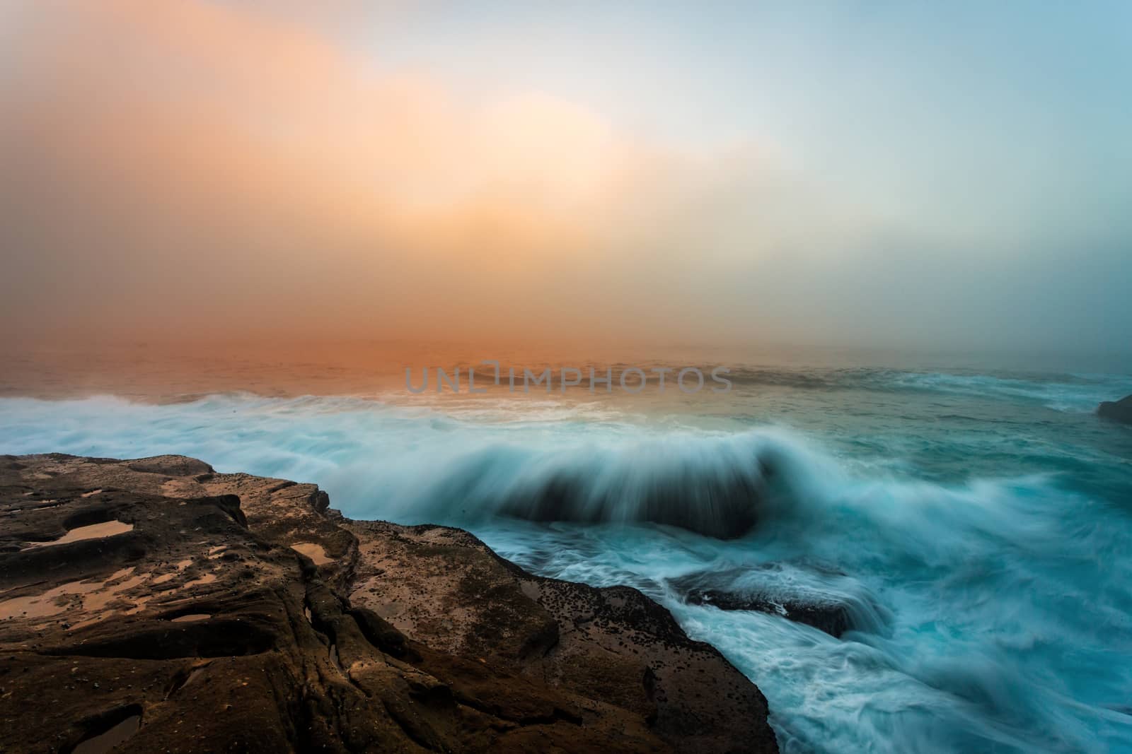 Sea fog and sunrise light on the Sydney coast seascape.  Space for copy