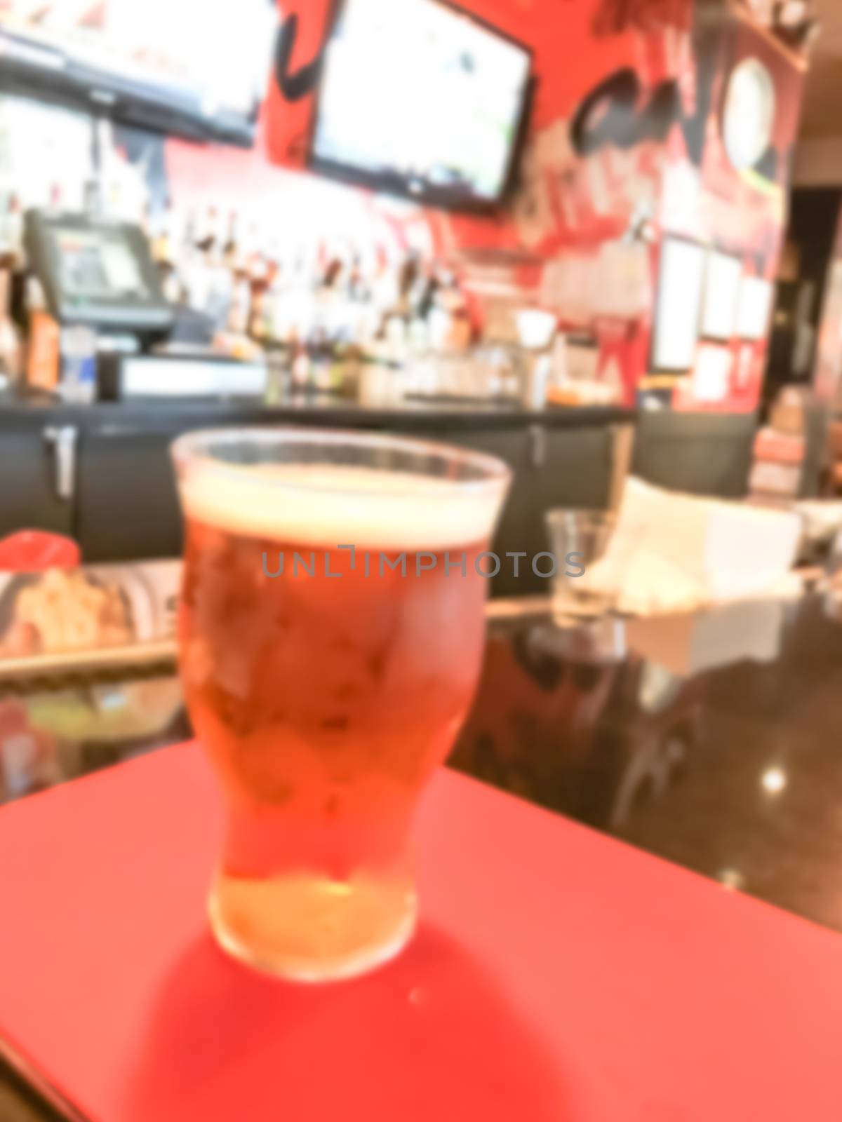 Blurry background beer mug and bar counter with many alcoholic drinks by trongnguyen