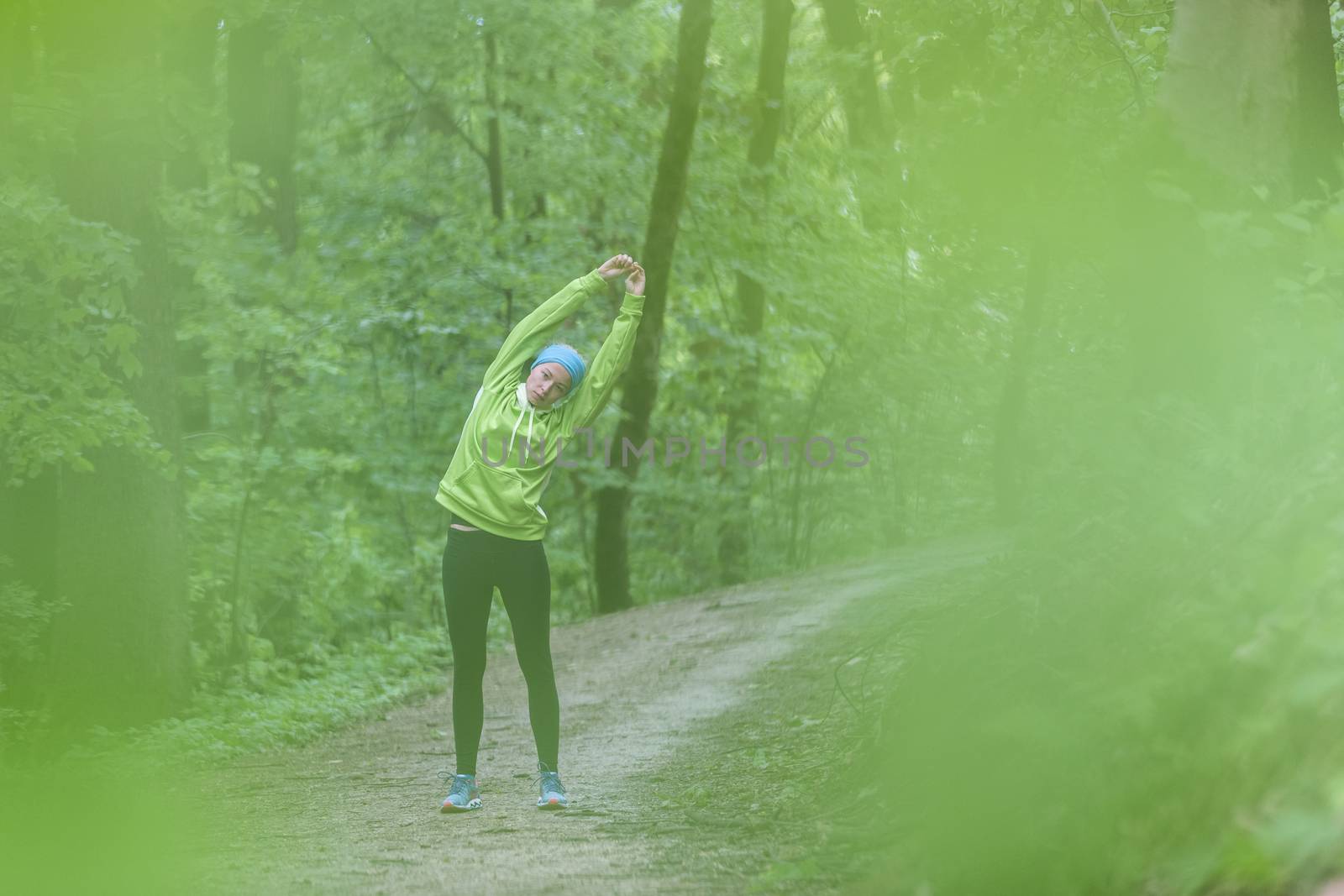 Sporty woman working out in forest. by kasto