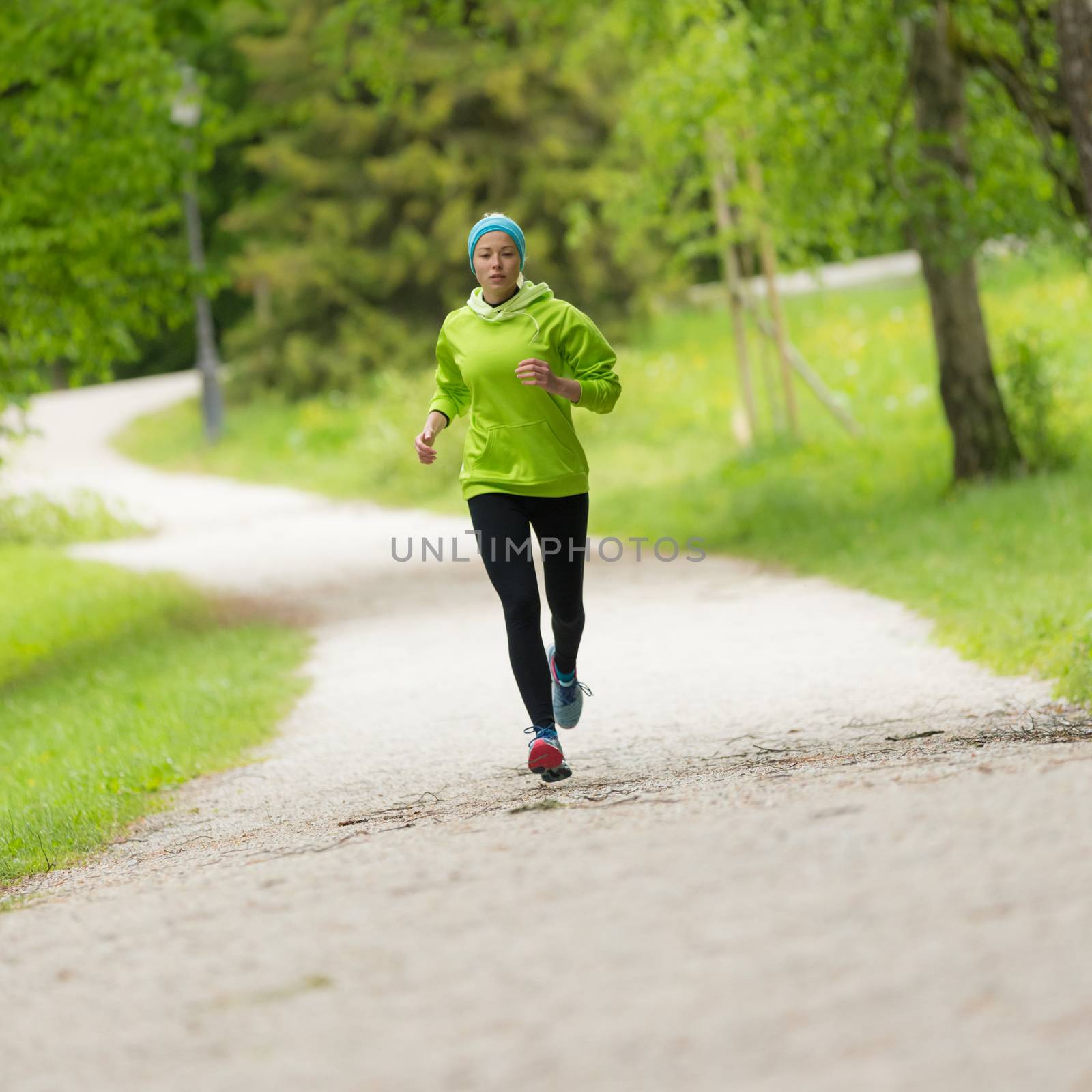 Sporty young female runner in city park. Running woman. Female runner during outdoor workout in nature. Fitness model outdoors. Weight Loss. Healthy lifestyle.
