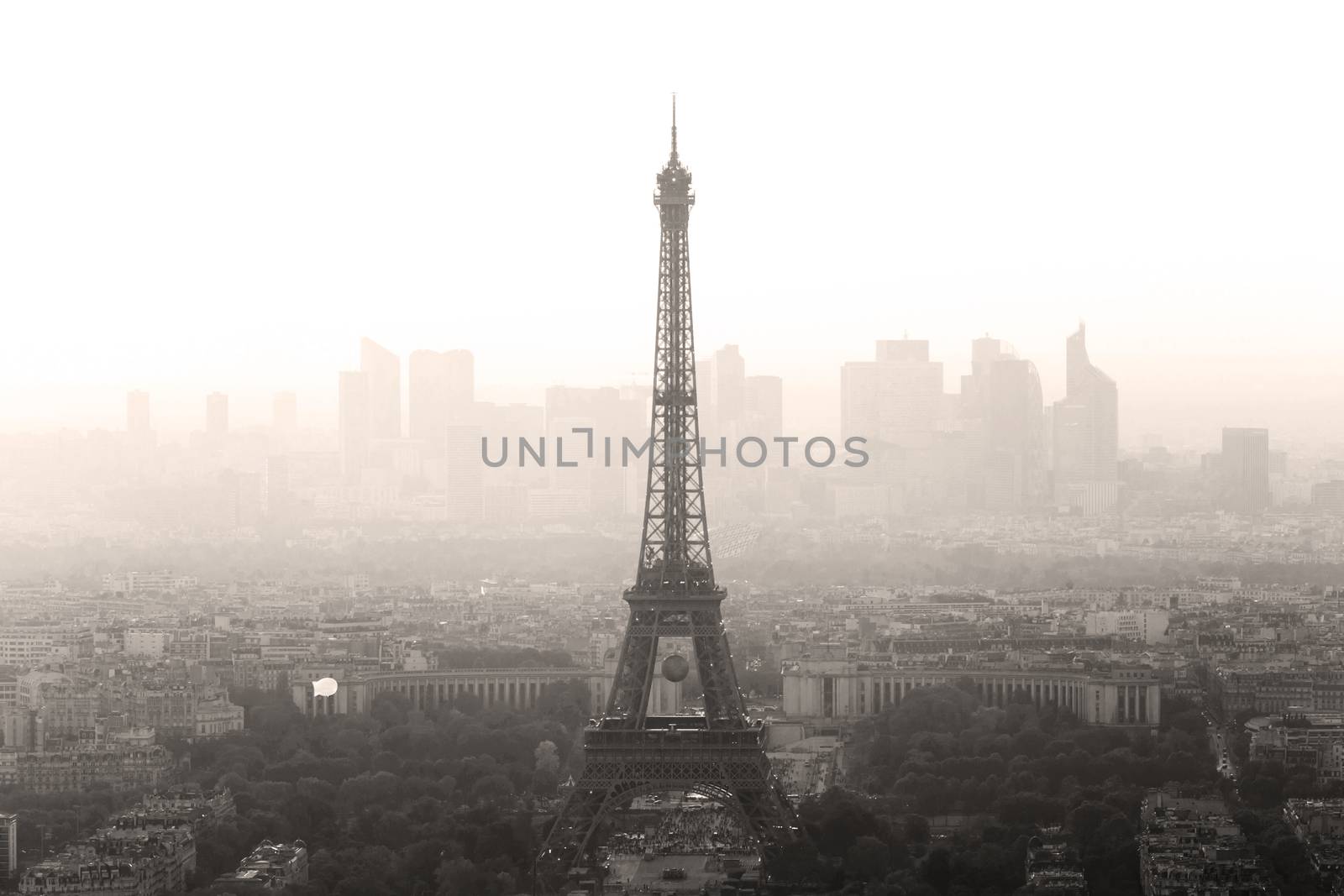 Aerial view of Paris with Eiffel tower and major business district of La Defence in background at sunset.