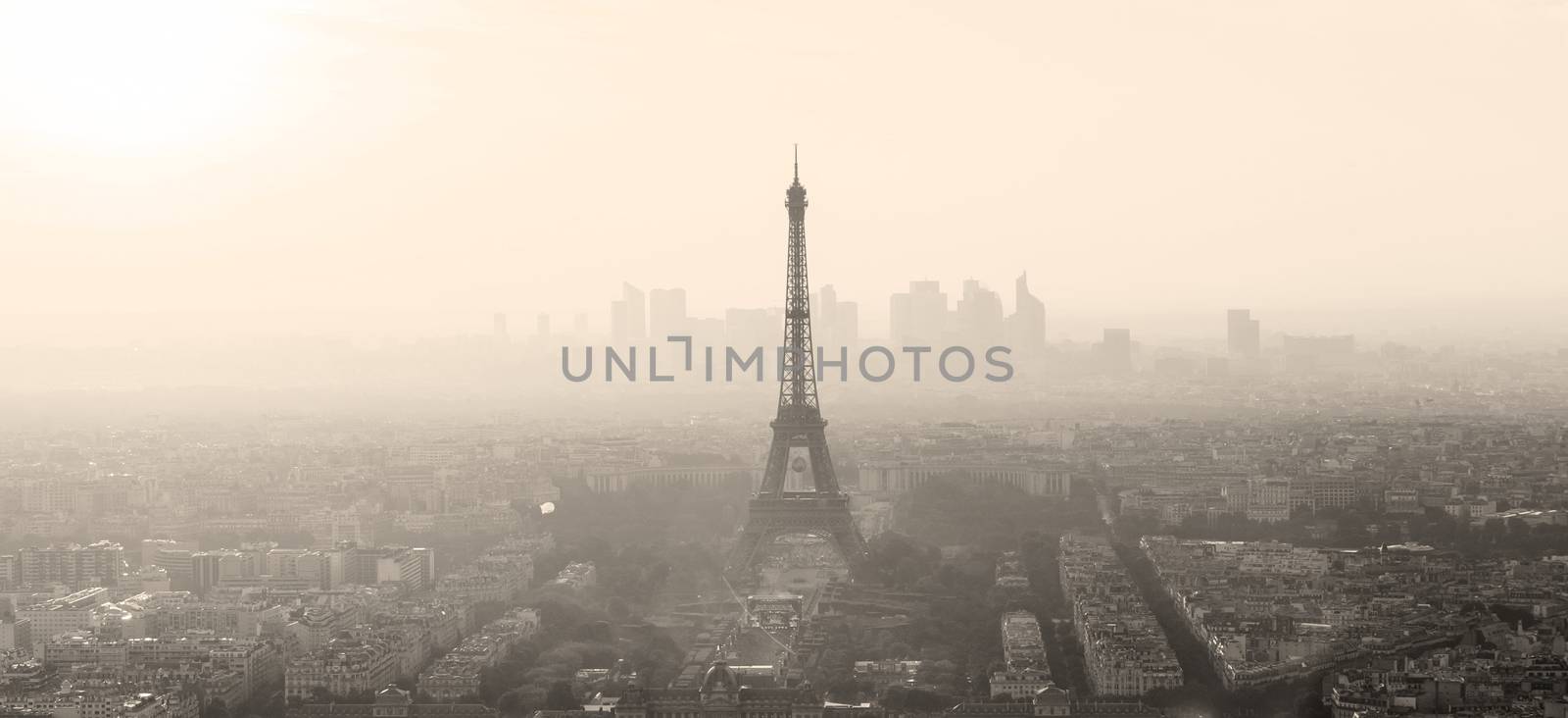 Aerial view of Paris with Eiffel tower and major business district of La Defence in background at sunset. Sepia toned monocrome image.