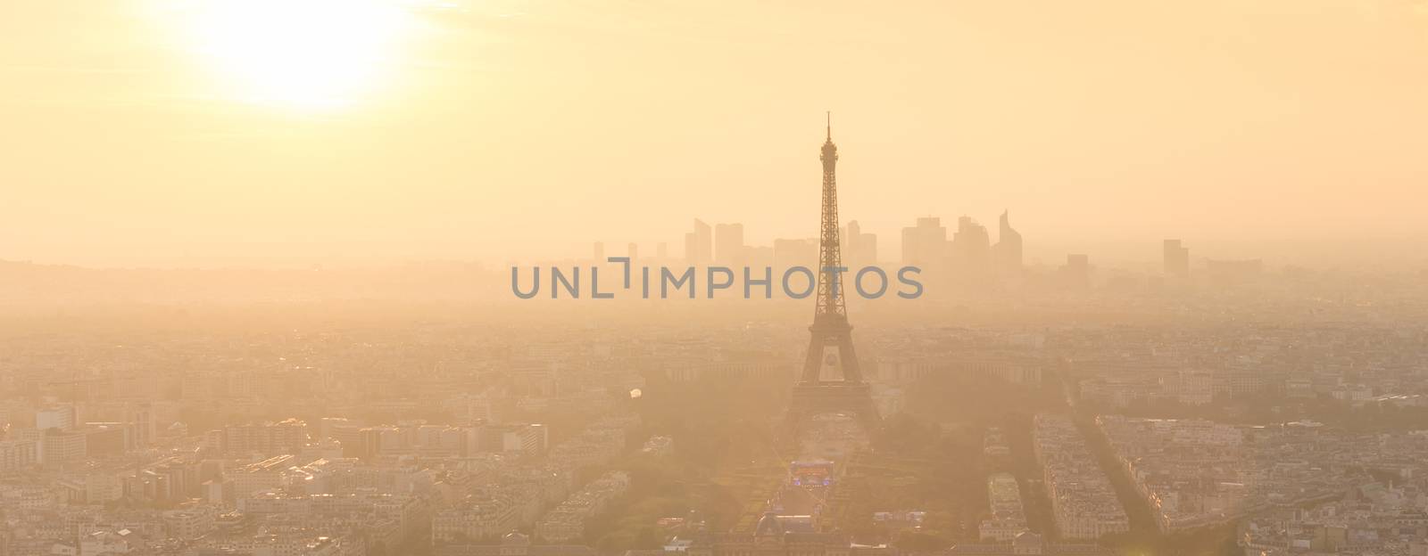 Aerial view of Paris with Eiffel tower and major business district of La Defence in background at sunset.