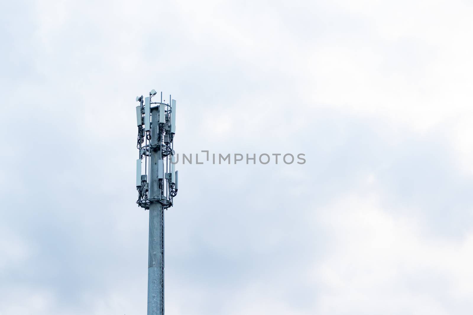 top of telecommunication tower against cloudy sky.