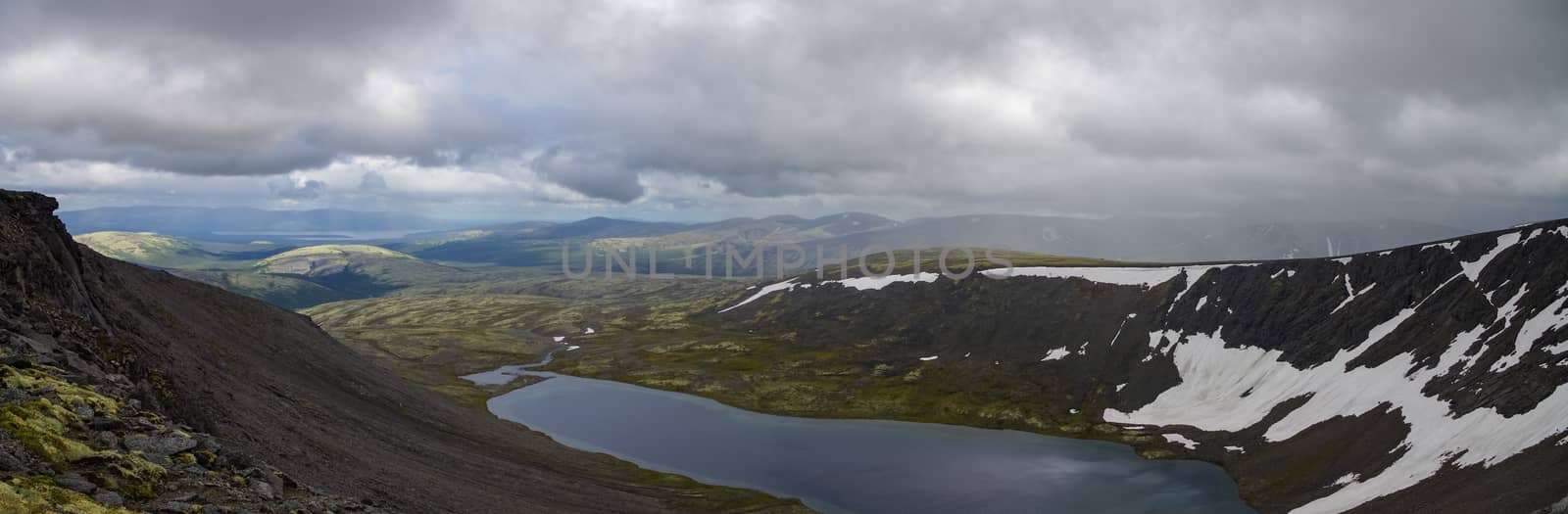 Mountain lake panorama in valley with mosses and rocks covered with lichens.  Khibiny mountains above the Arctic circle, Kola peninsula, Russia