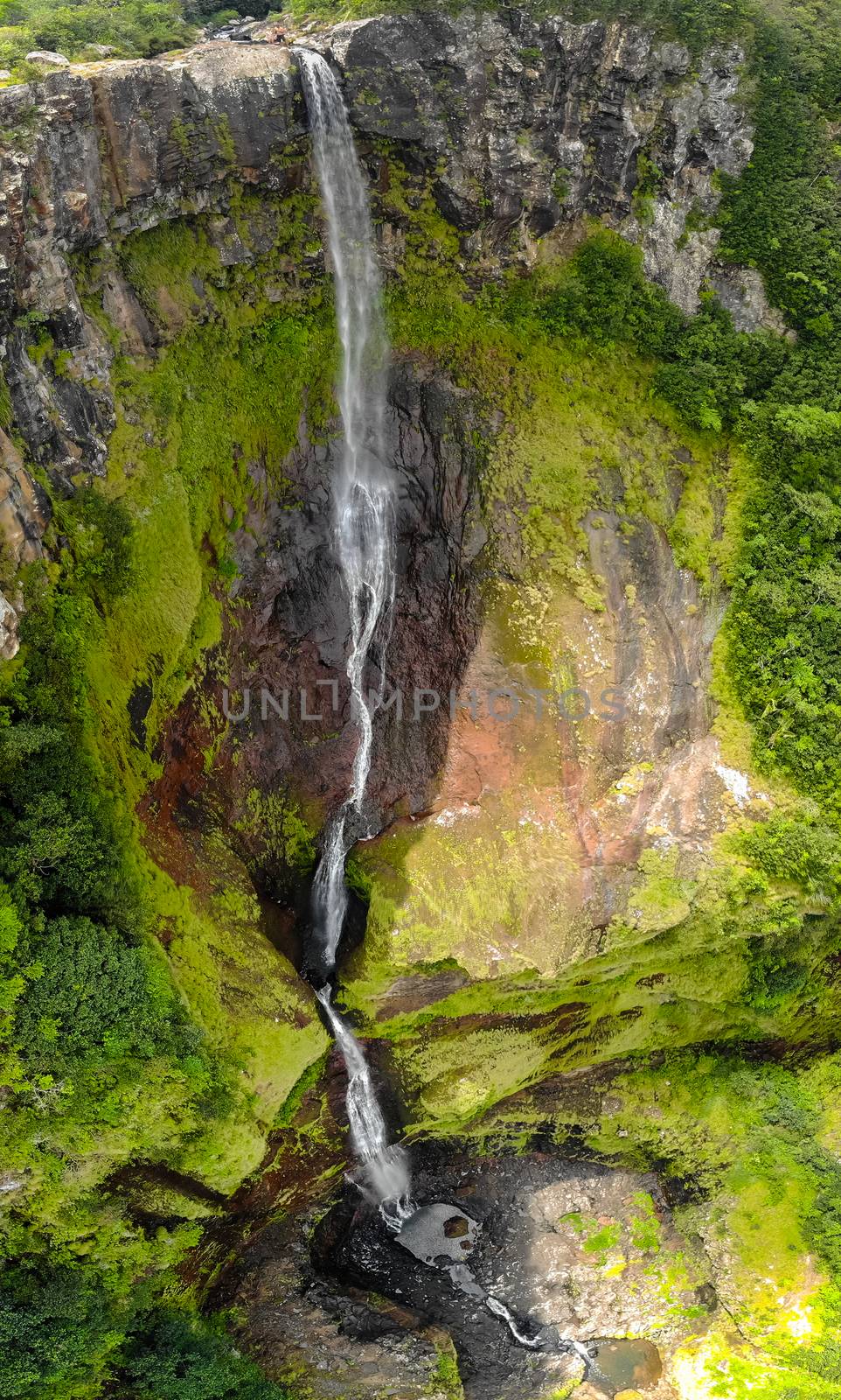 Aerial top view perspective of 500 feet waterfall in the tropical island jungle of Black river gorges national park on Mauritius island.