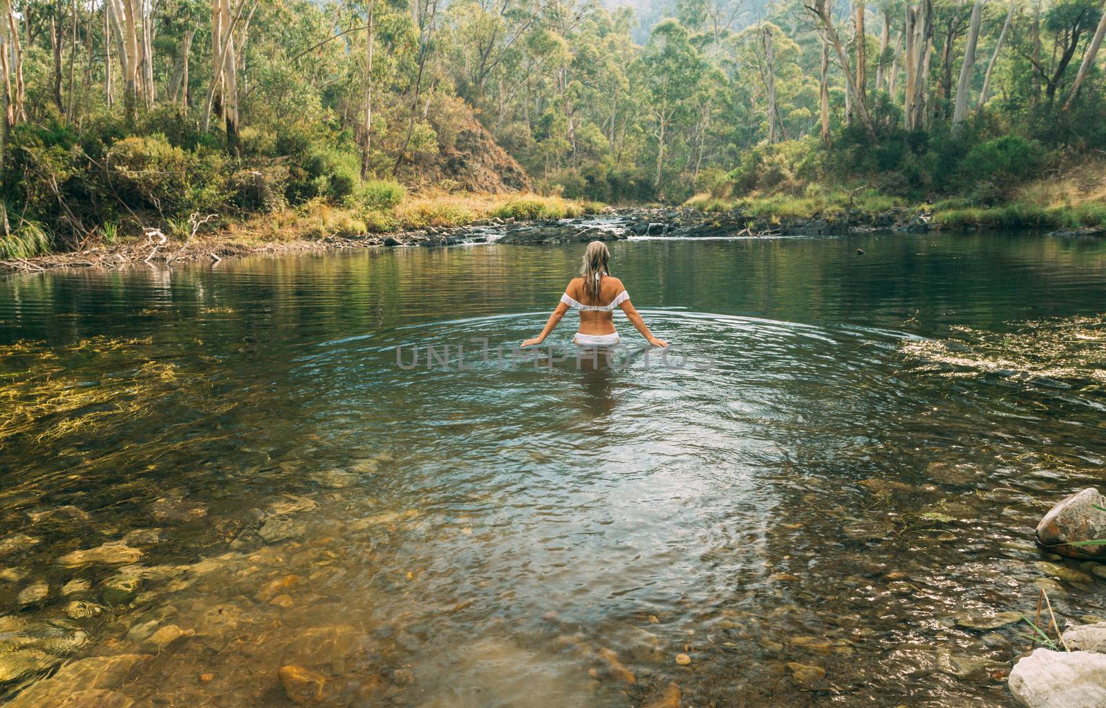 Woman wading in thermal springs in Australia by lovleah