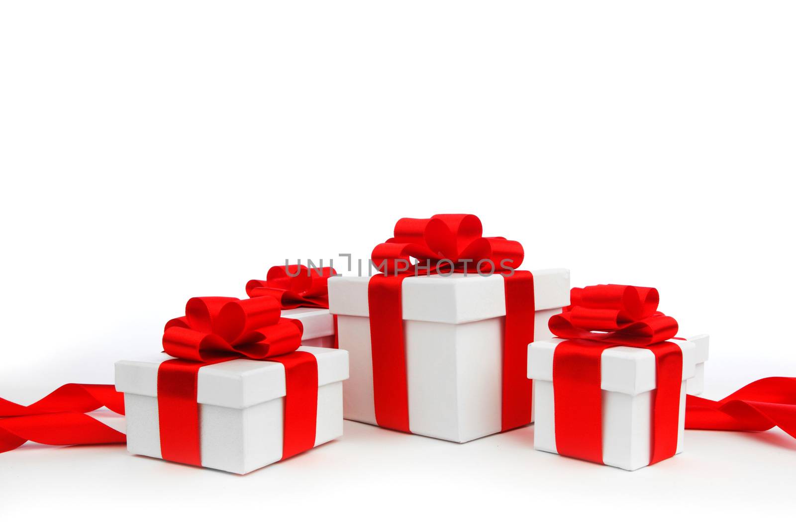 Holiday presents wrapped in white paper with red ribbons, isolated on white